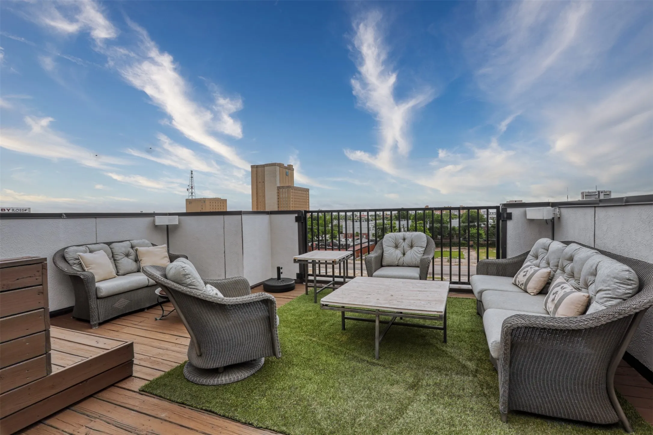 Rooftop terrace featuring wood decking and metal perimeter railing