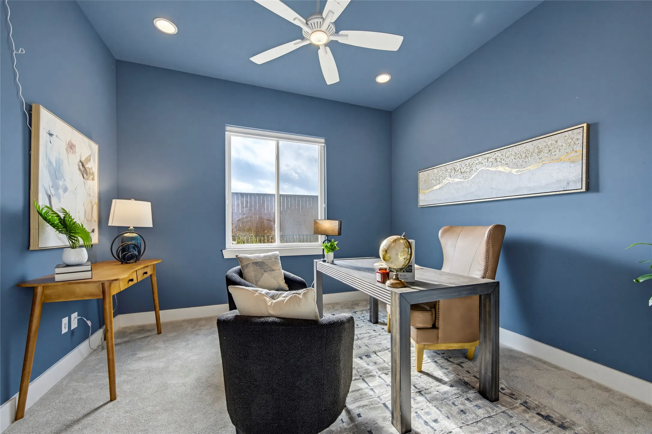 Room featuring neutral carpeting, a dual-pane sliding window, recessed lighting, and a white ceiling-mounted fan with integrated light