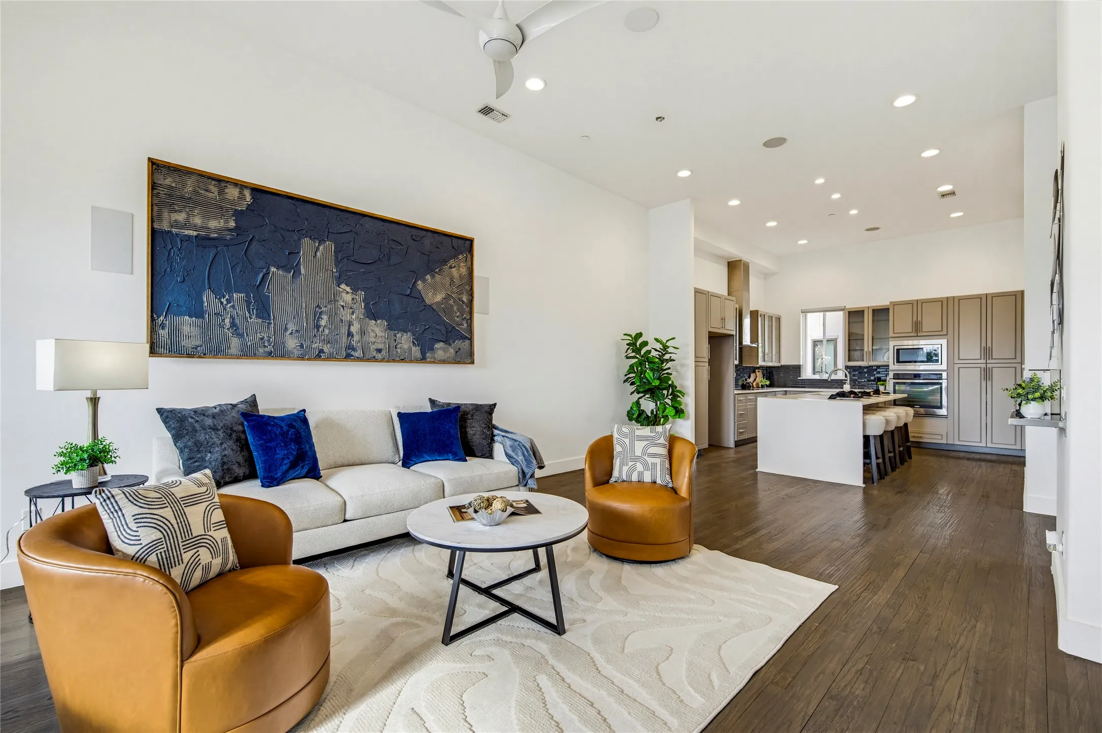 Open-concept interior featuring high ceilings, wood-finish flooring, recessed lighting, and a ceiling fan