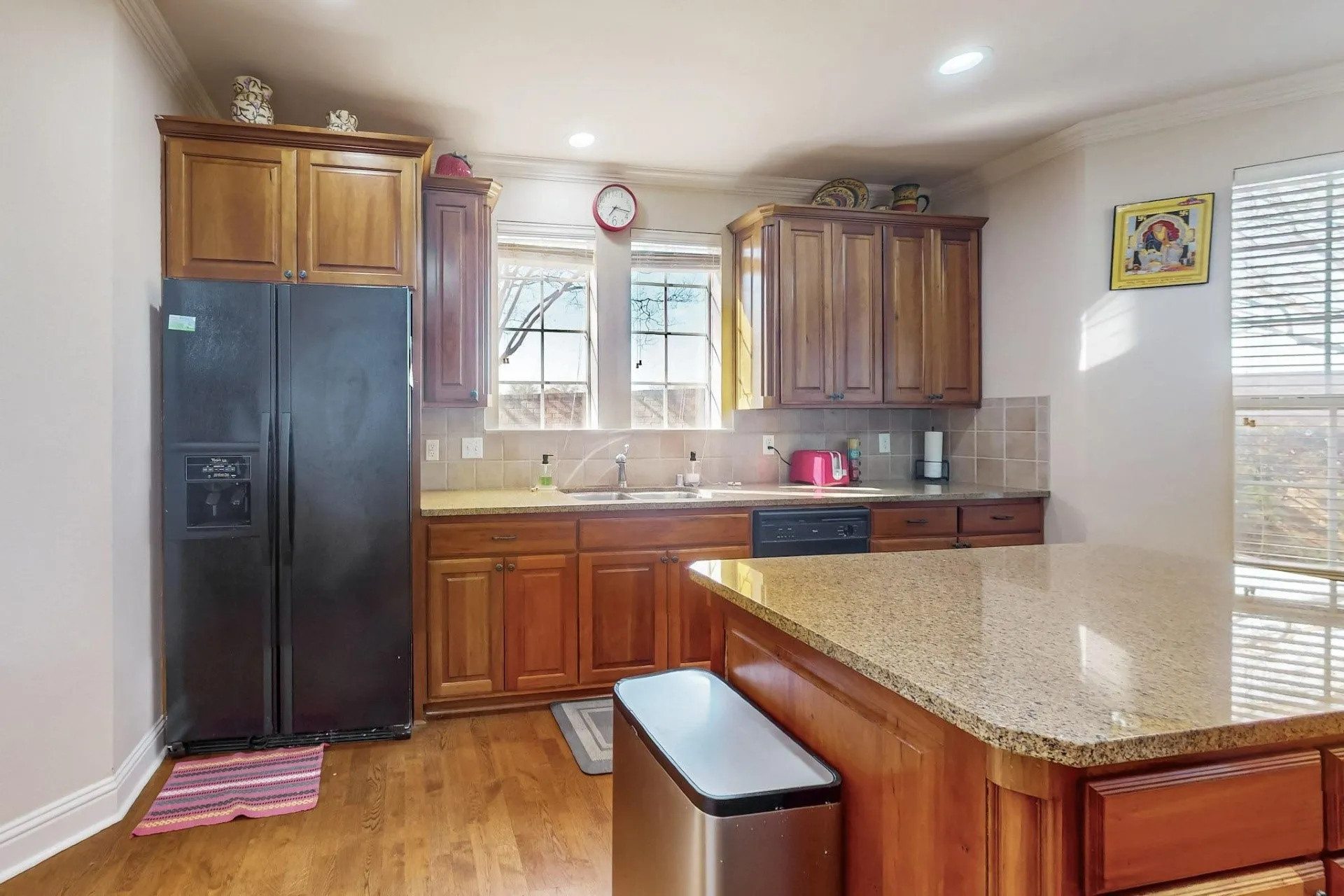 Kitchen featuring wood cabinetry, stone countertops, a center island, recessed lighting, and tile backsplash