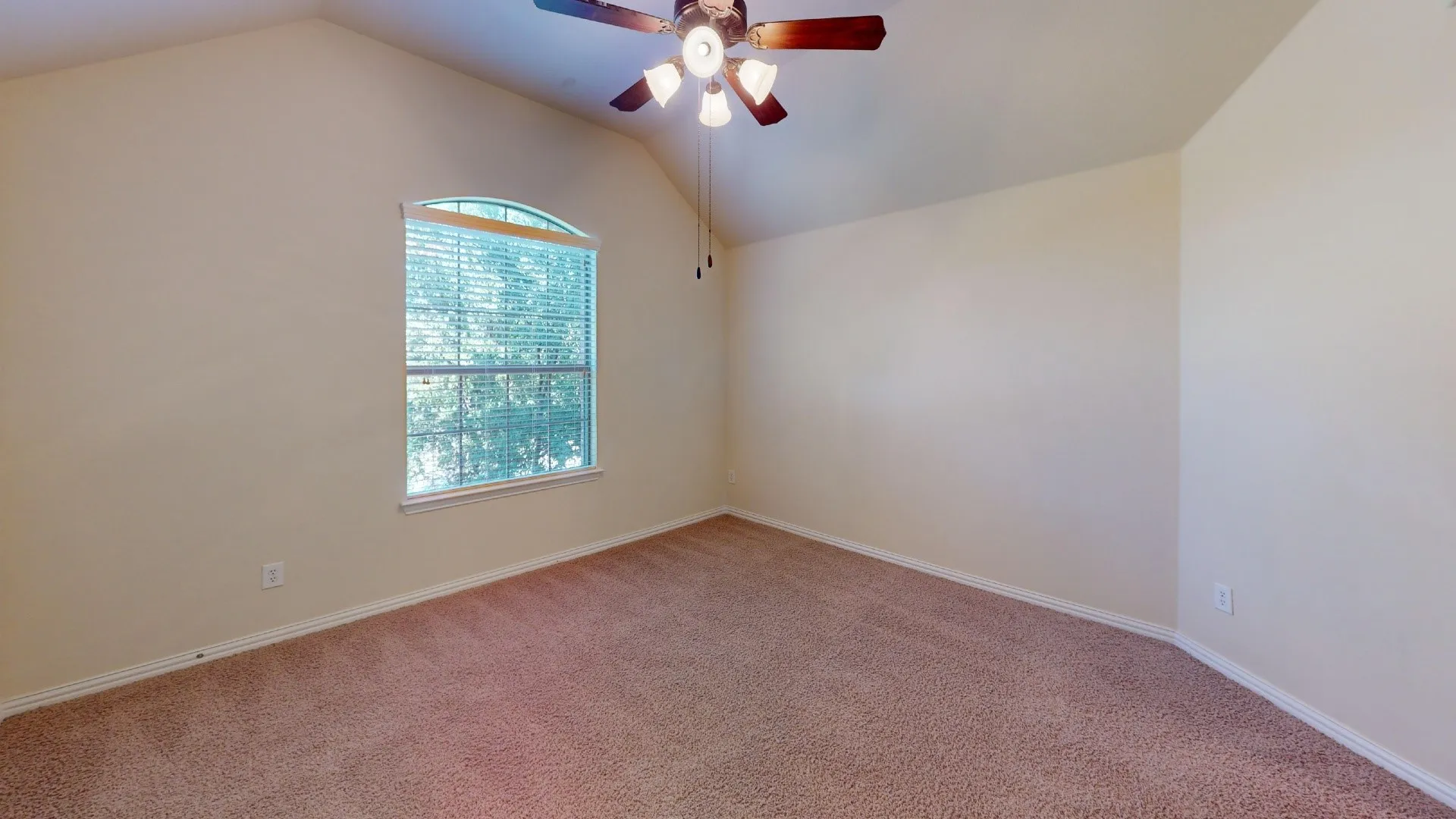 Vaulted ceilings, arched window with integrated blinds, and a multi-light ceiling fan
