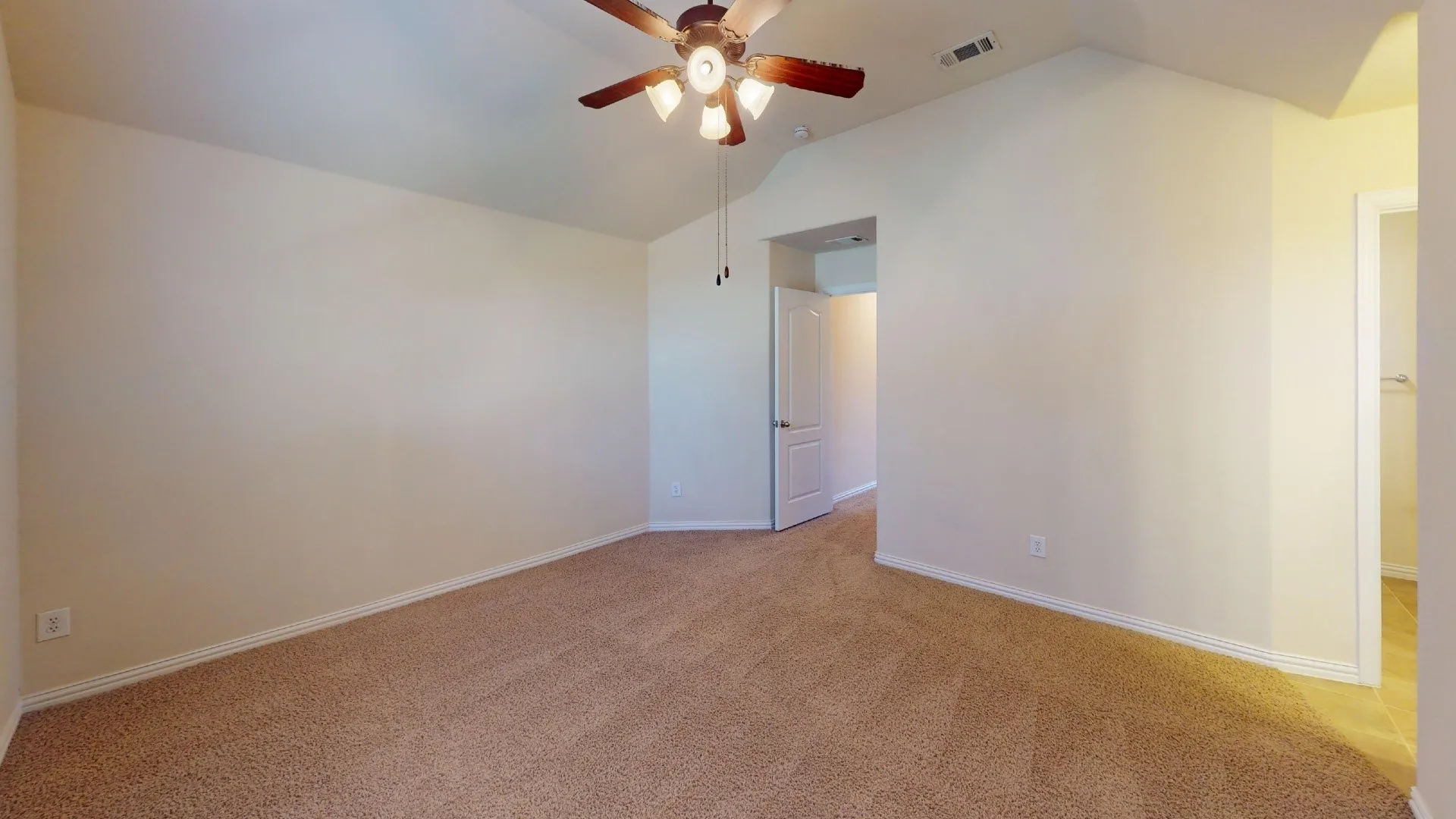 Vaulted ceilings with a multi-blade ceiling fan and neutral wall-to-wall carpeting