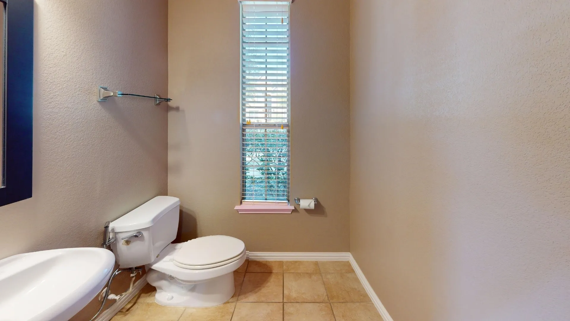 Powder room featuring tile flooring, a pedestal sink, a tall narrow window with horizontal blinds, and chrome hardware