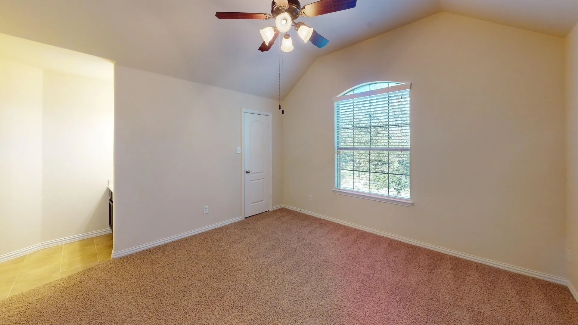 Room featuring vaulted ceilings, neutral wall tones, arched window with integrated blinds, carpeting, and a multi-light ceiling fan