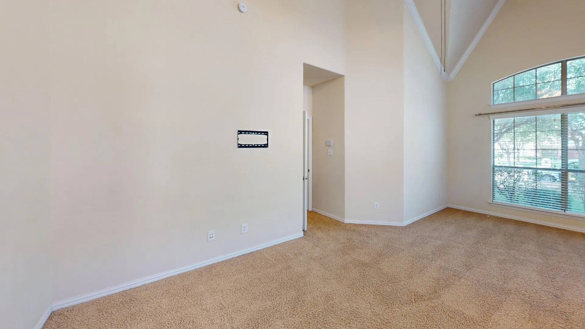 Vaulted ceilings featuring expansive windows, neutral wall finishes, and wall-to-wall carpeting