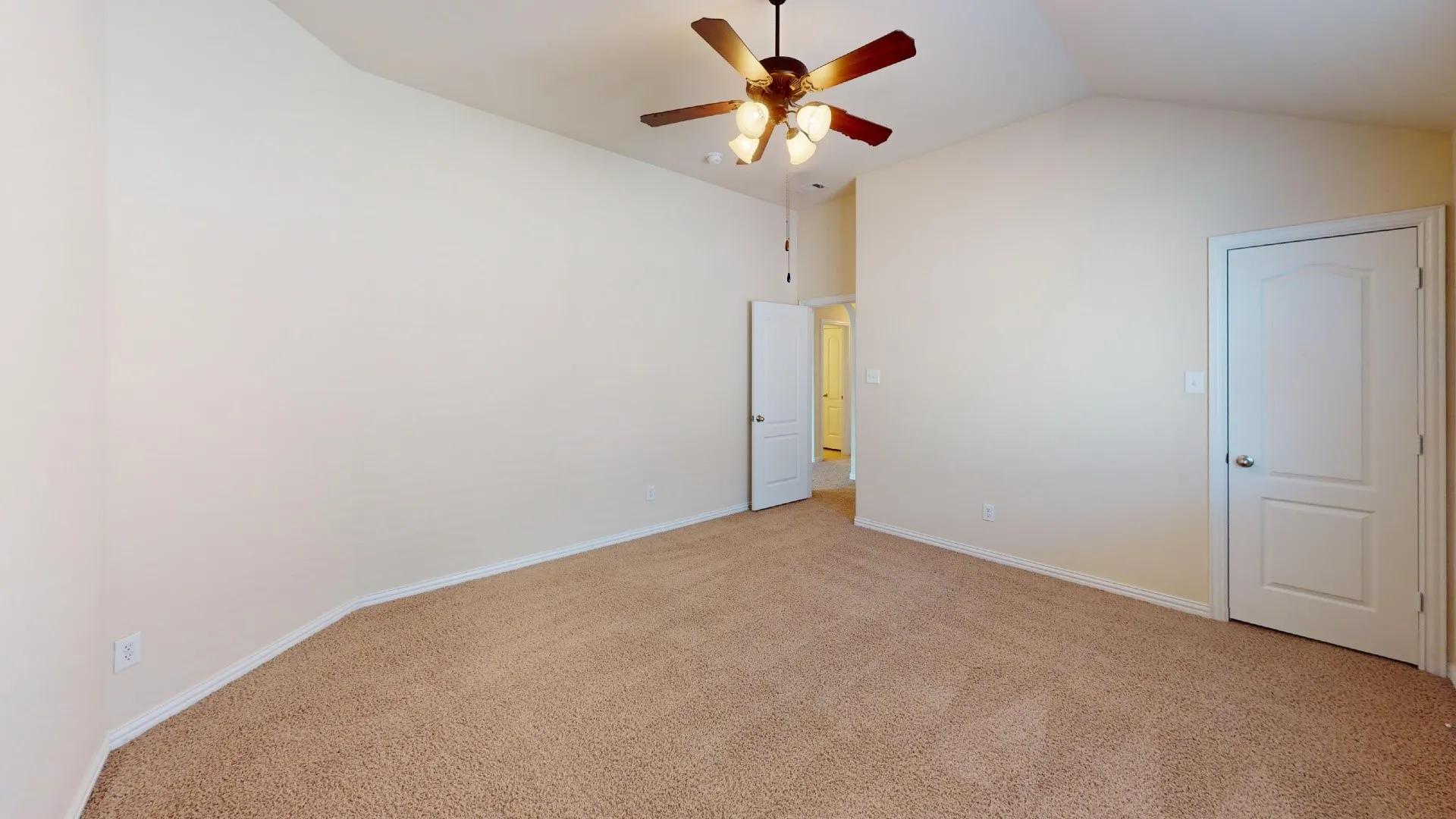 Vaulted ceilings, neutral wall color, carpeting, and a ceiling fan with multi-light fixture