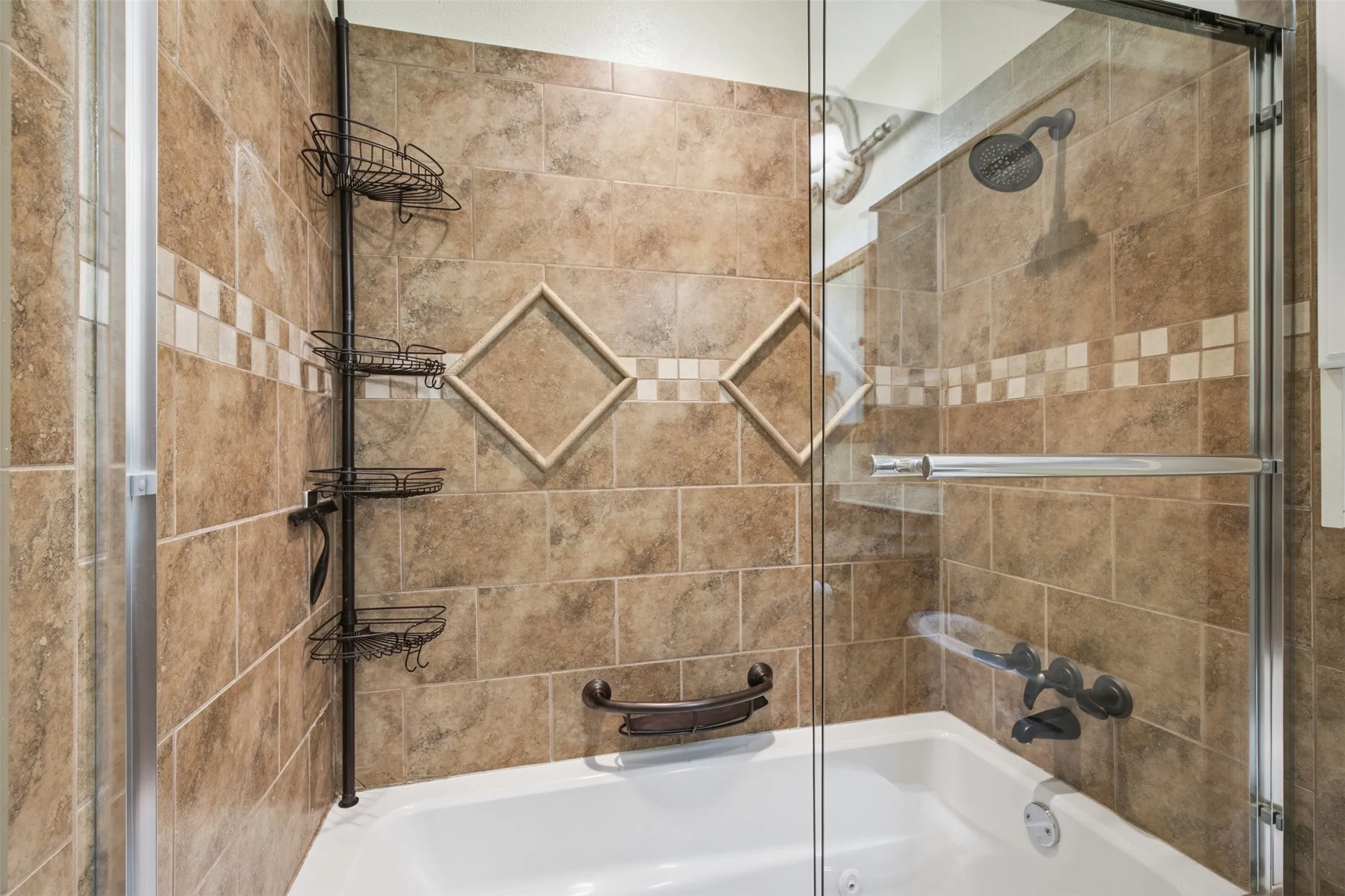 Tiled bath and shower combination featuring a glass enclosure