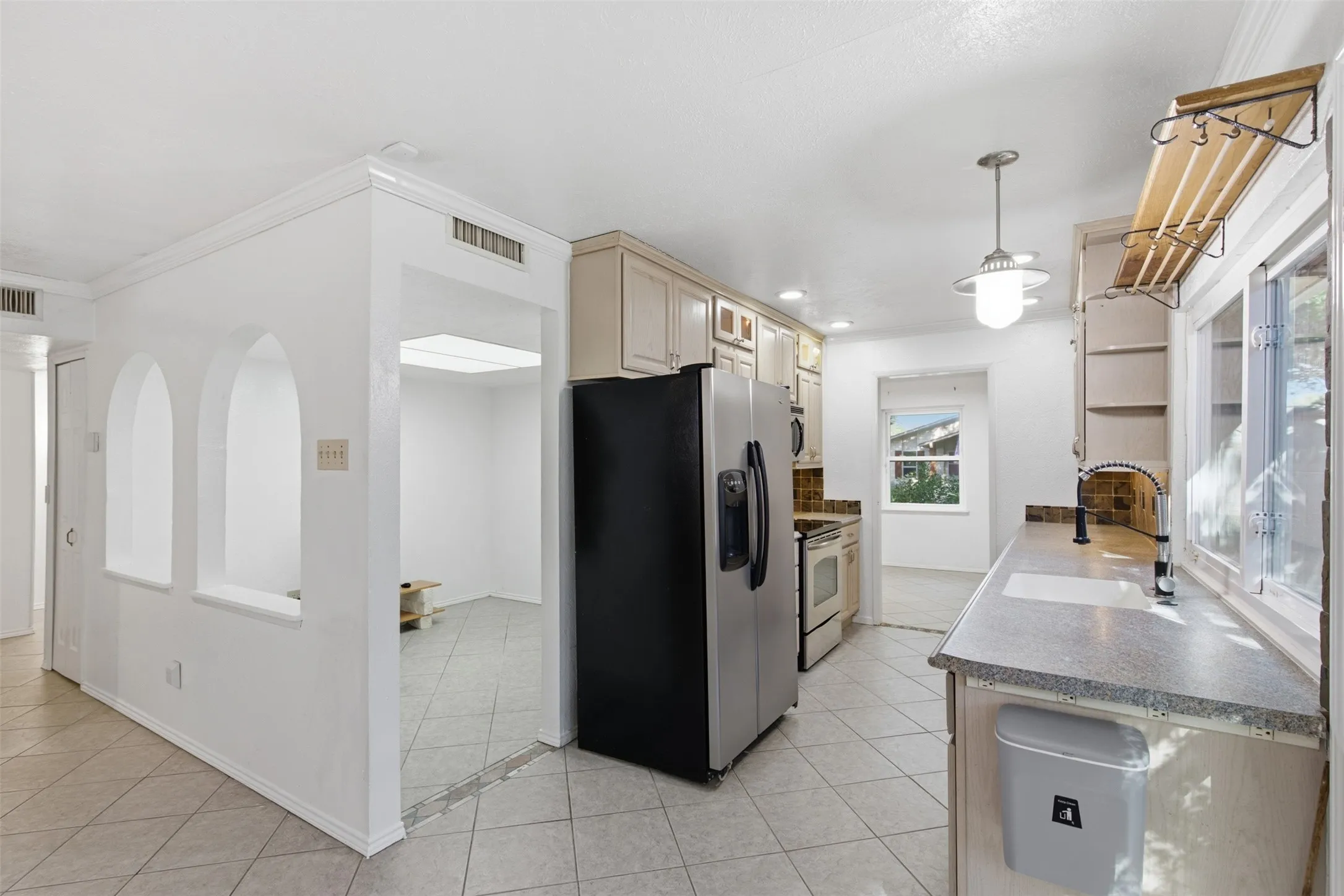 Kitchen featuring light-finish cabinetry, stainless steel appliances, and a tile backsplash