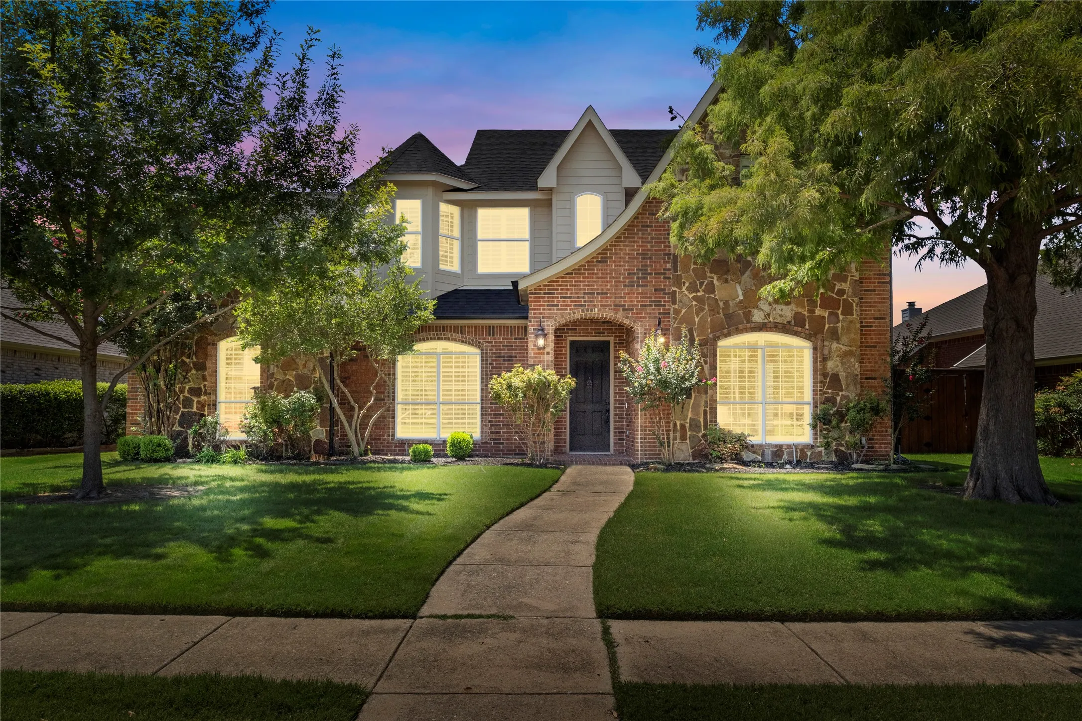 Two story stone and brick home with arch details
