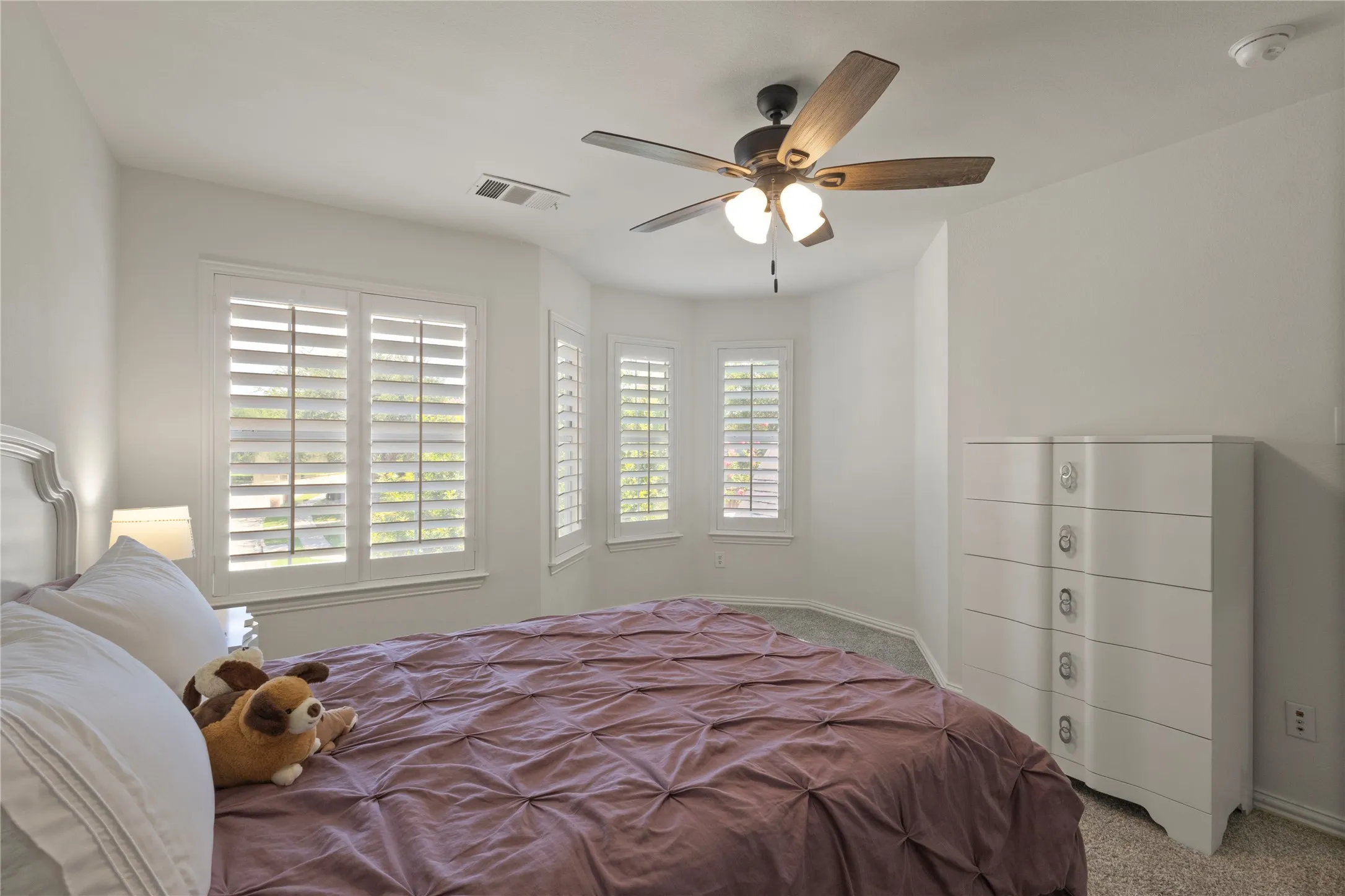 Rounded wall with plantation shutters in upstairs bedroom