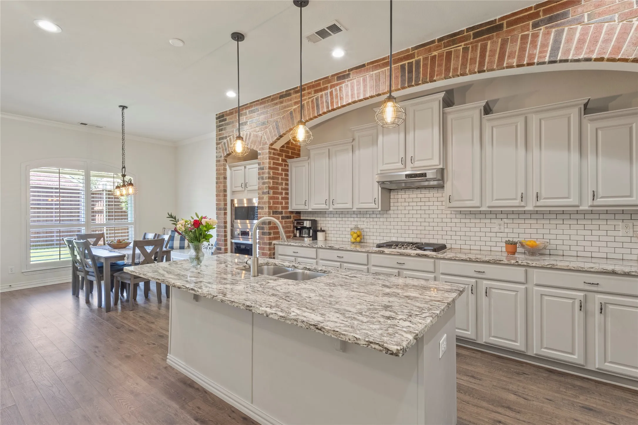 Brick accent wall, neutral granite countertop, open