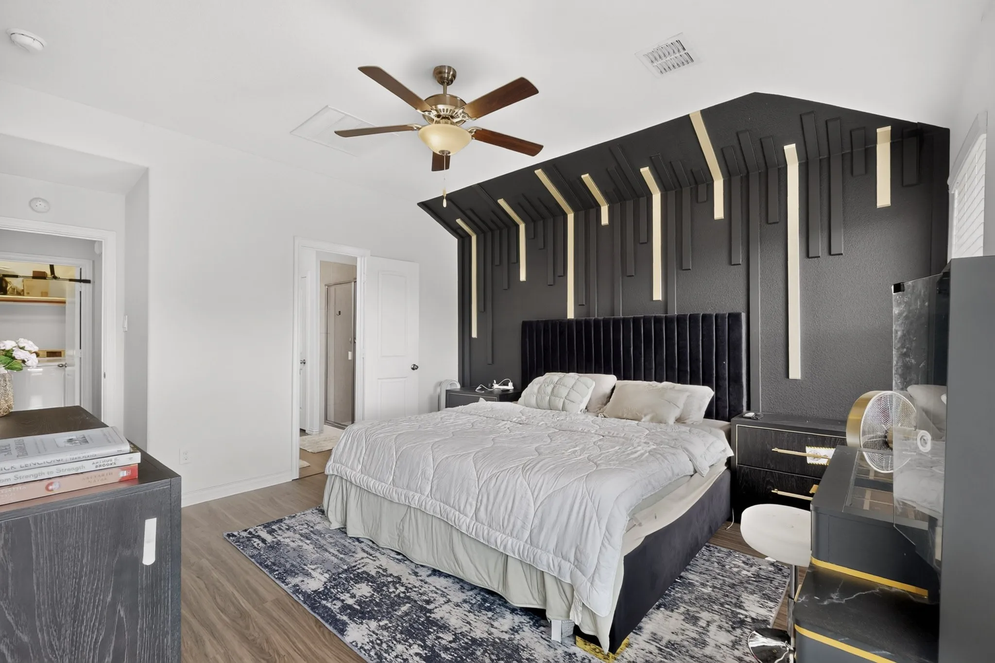 Vaulted ceiling featuring a custom geometric accent wall with integrated vertical lighting and a multi-blade ceiling fan with an integrated light fixture