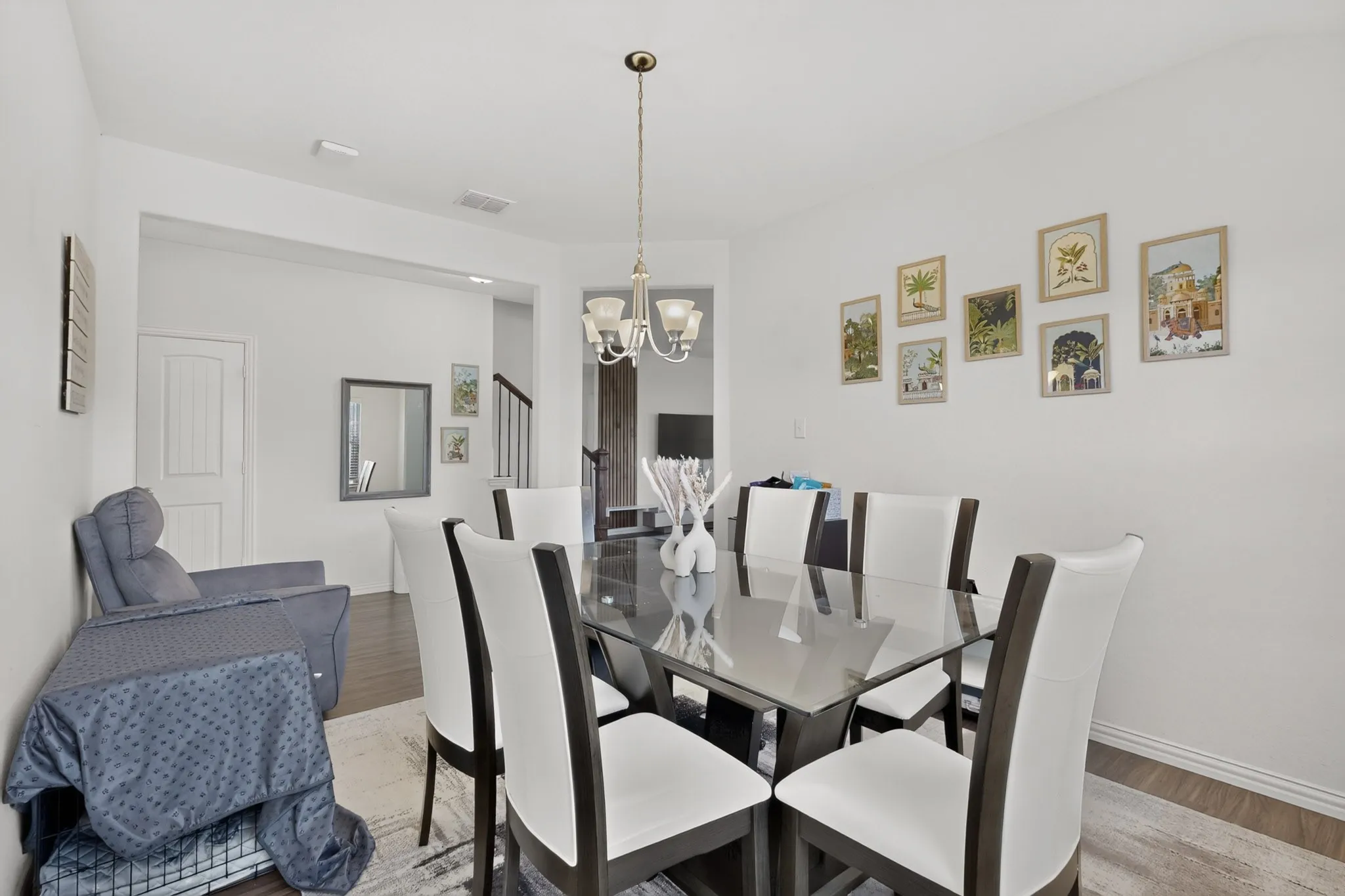Dining area featuring wood-finish flooring, a multi-light metal chandelier, and neutral wall tones