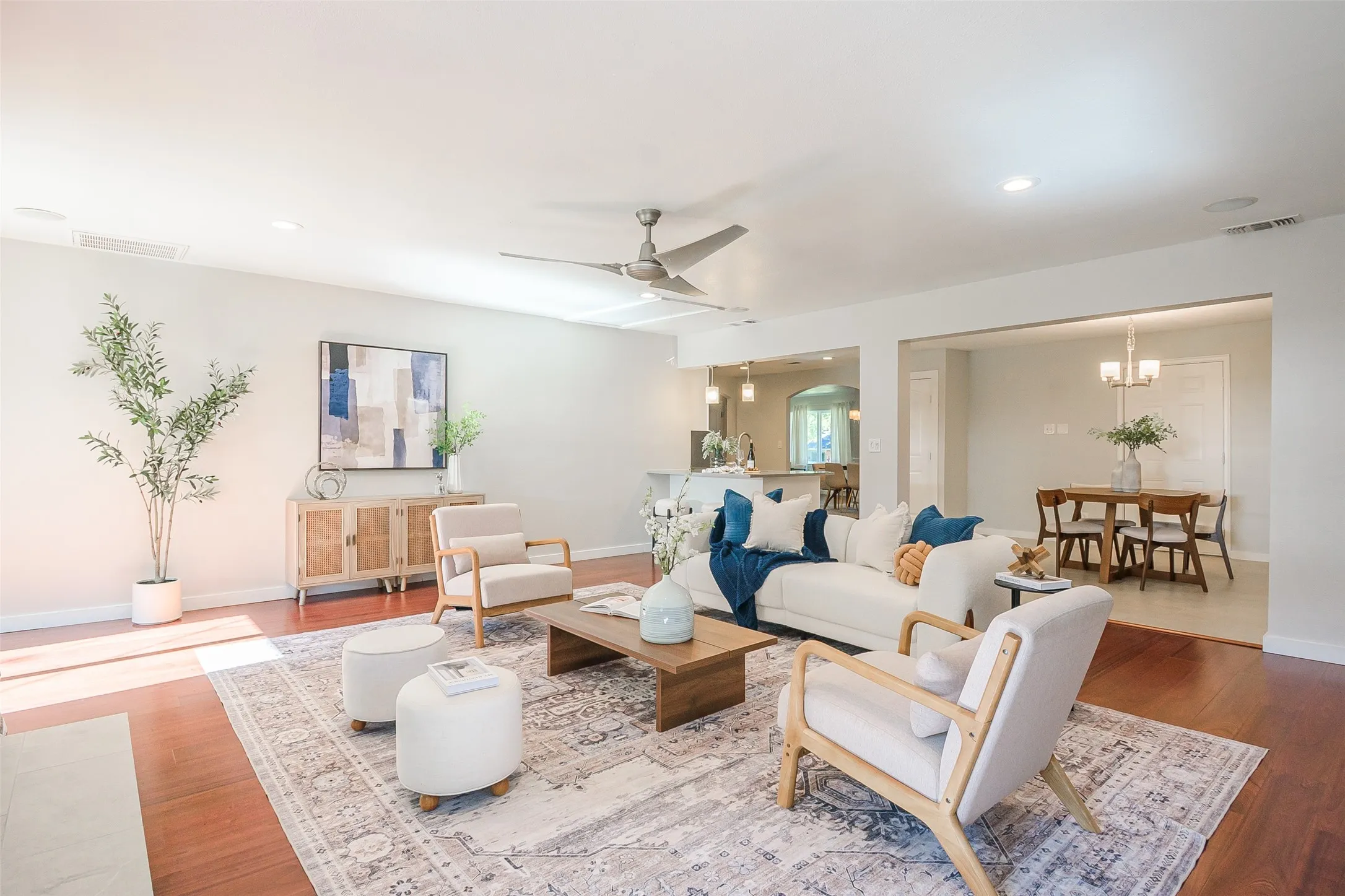 Open-concept interior featuring wood-finish flooring, recessed lighting, and a brushed-metal ceiling fan