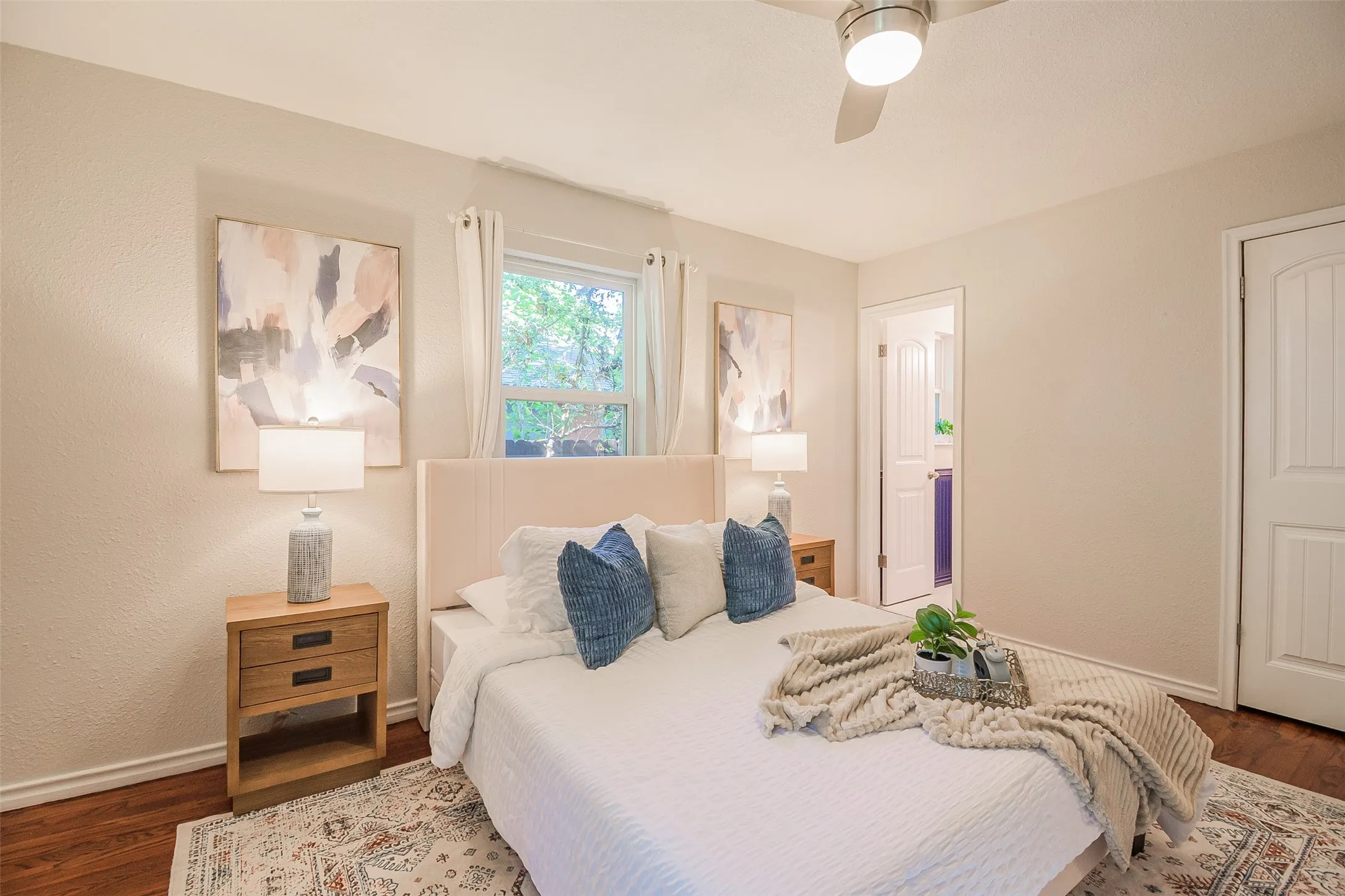 Neutral-toned walls, wood-finish flooring, ceiling fan with integrated lighting, and multi-panel interior doors