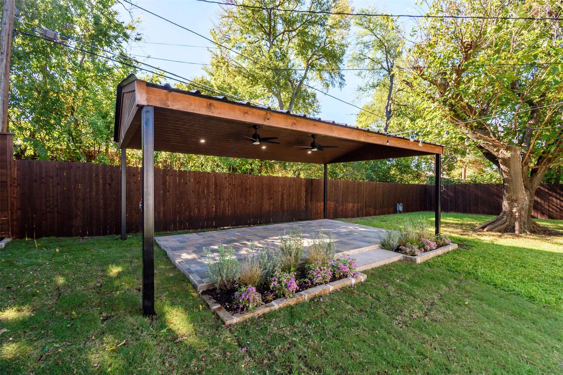 Covered patio featuring a wood-beam structure, metal roofing, dual ceiling fans, recessed lighting, and stone paver flooring
