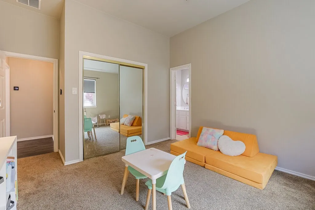 Neutral wall paint, carpeting, and sliding mirrored closet doors