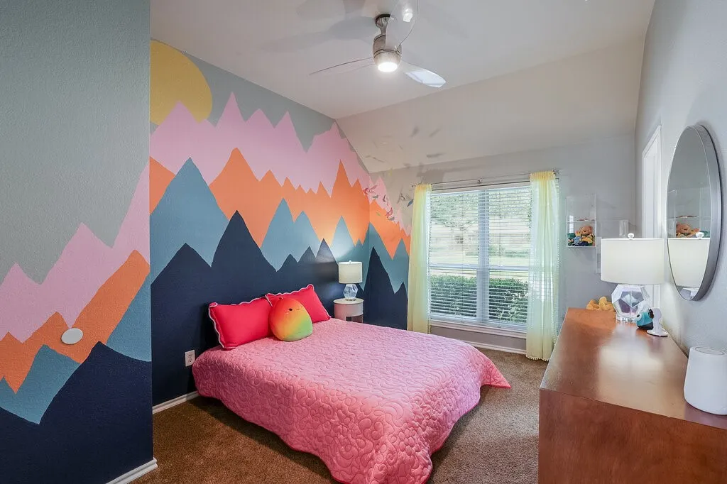Vaulted ceilings, large window with horizontal blinds, and a brushed nickel ceiling fan with integrated lighting