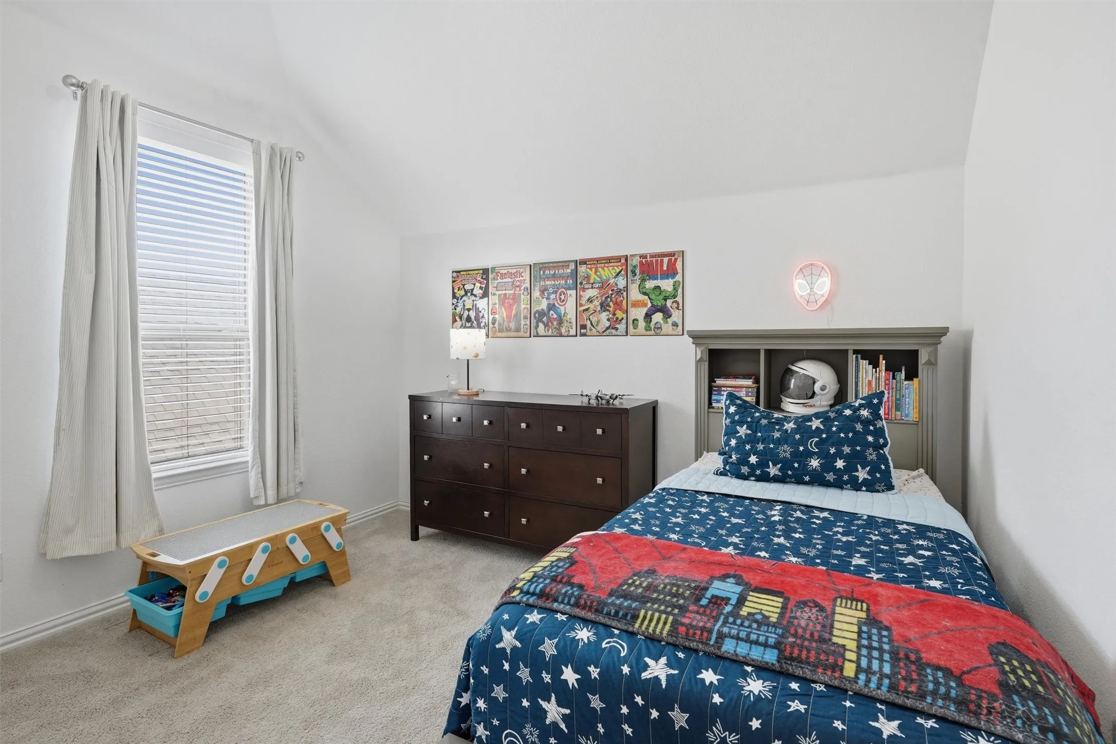 Additional secondary bedroom featuring vaulted ceilings, soft neutral carpeting, and bright natural light. Offers a comfortable layout designed for easy family living, relaxation, or play.