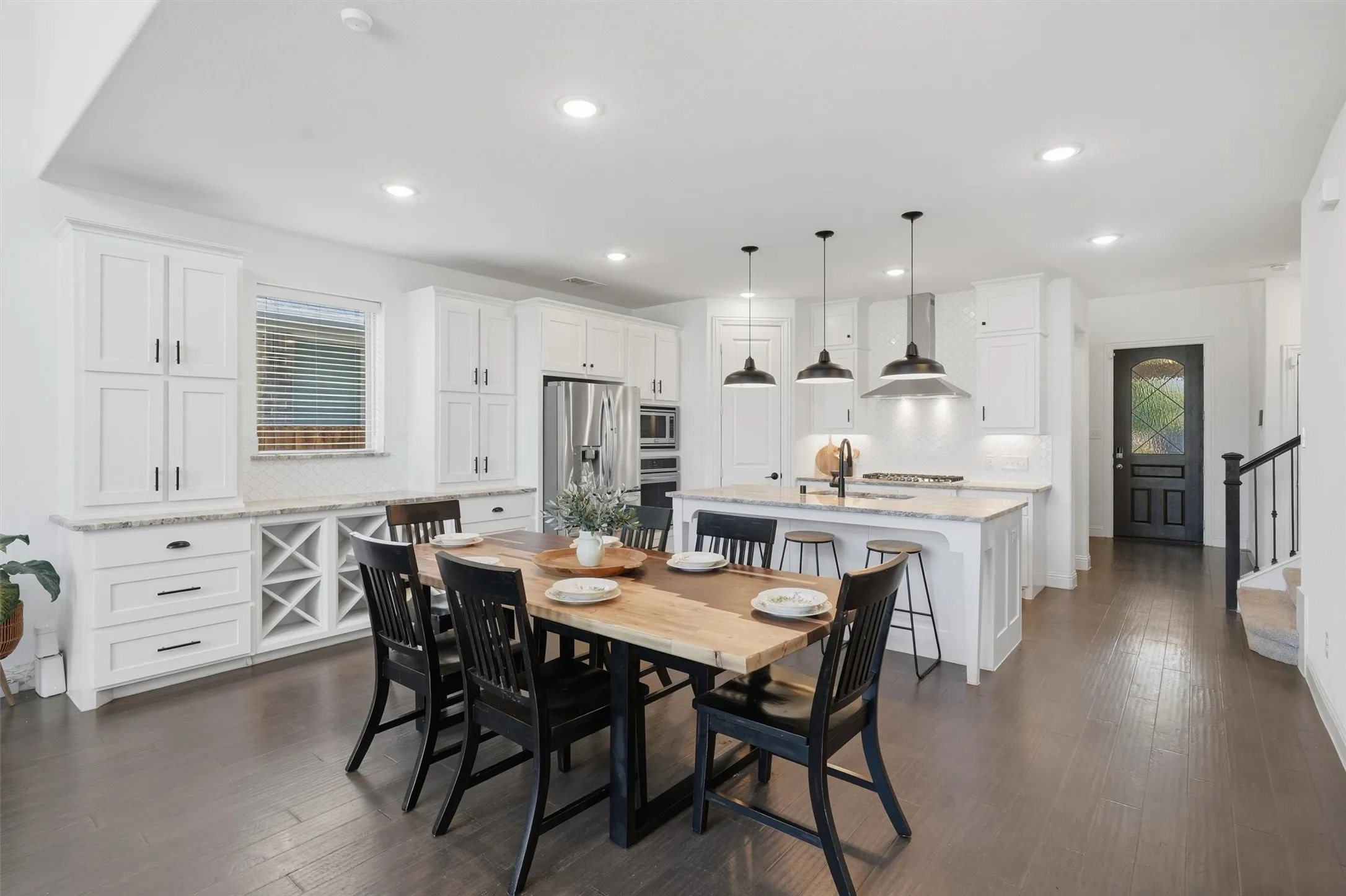The dining area showcasing the custom built-in wine rack and serving buffet. Highlights the smooth connection to the kitchen for effortless hosting and family dining