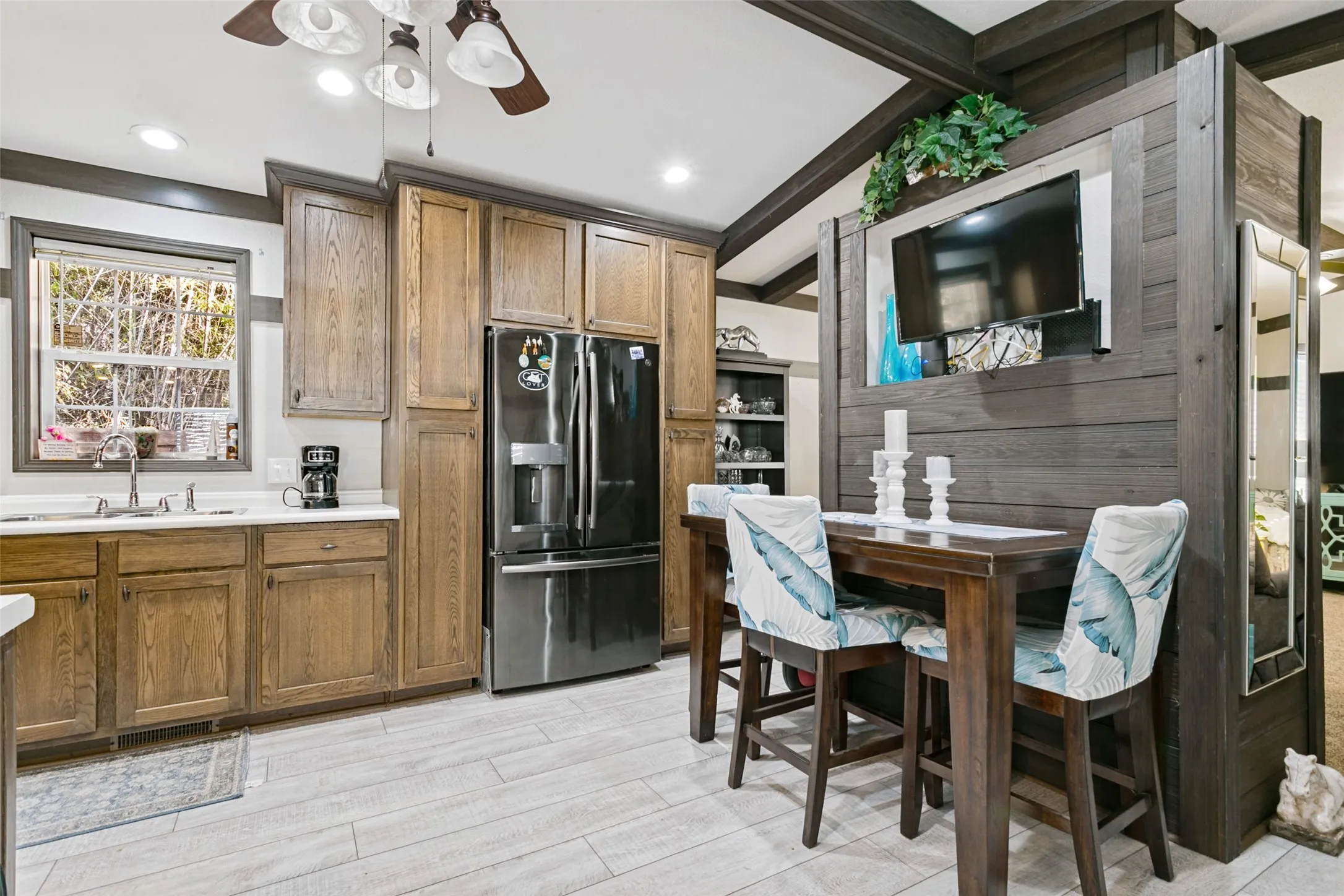 Kitchen featuring wood cabinetry, stainless steel appliances, tile flooring, and a decorative wood-paneled room divider