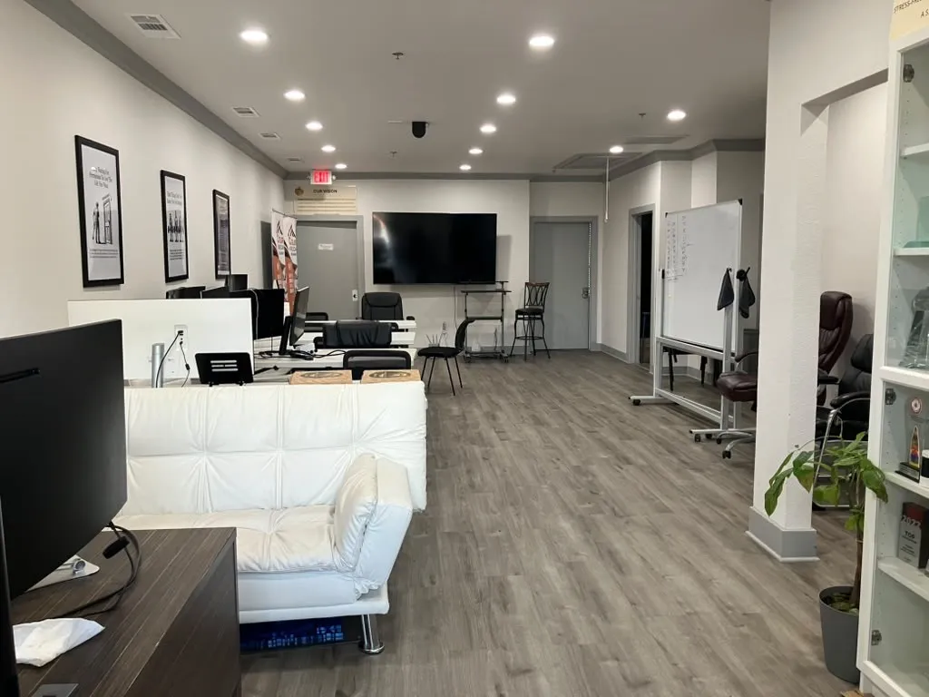 Recessed ceiling lighting, wood-finish flooring, white walls, gray trim, and multiple doorways