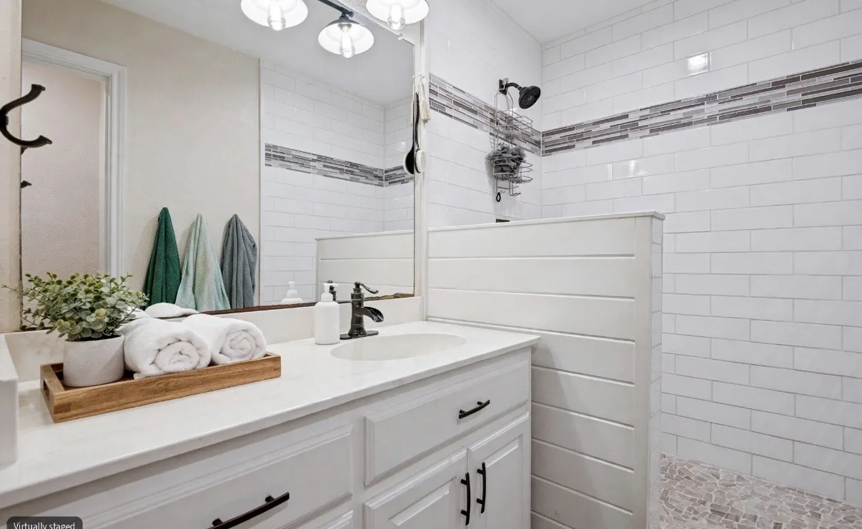 he remodeled secondary bathroom features a modern stand-up shower, offering a fresh, updated look with everyday convenience.
