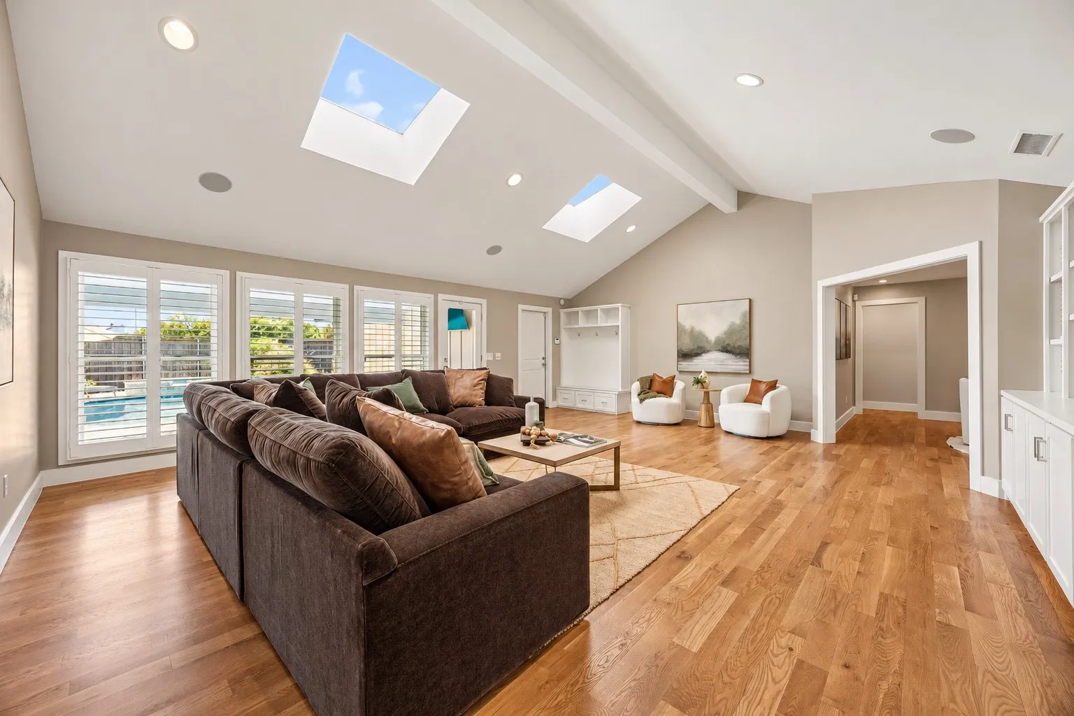 Family room featuring custom storage nook near garage door. Functional and beautiful.