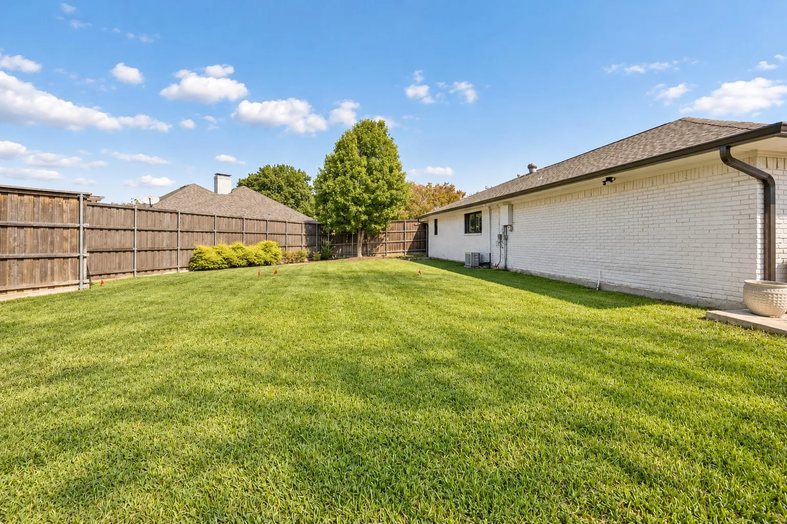 Spacious backyard featuring a manicured lawn on over one-third acre lot connected all the way around the property by a gated fence. Enjoy the pool or yard all in one.