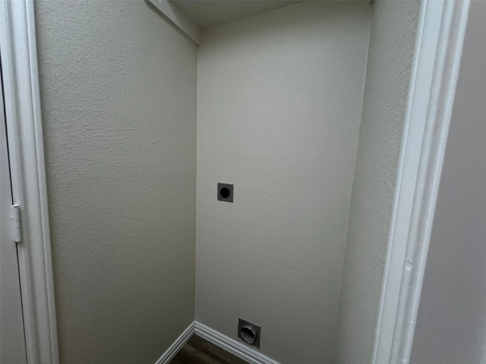 Dedicated utility alcove featuring neutral wall finishes and integrated ventilation and exhaust ports