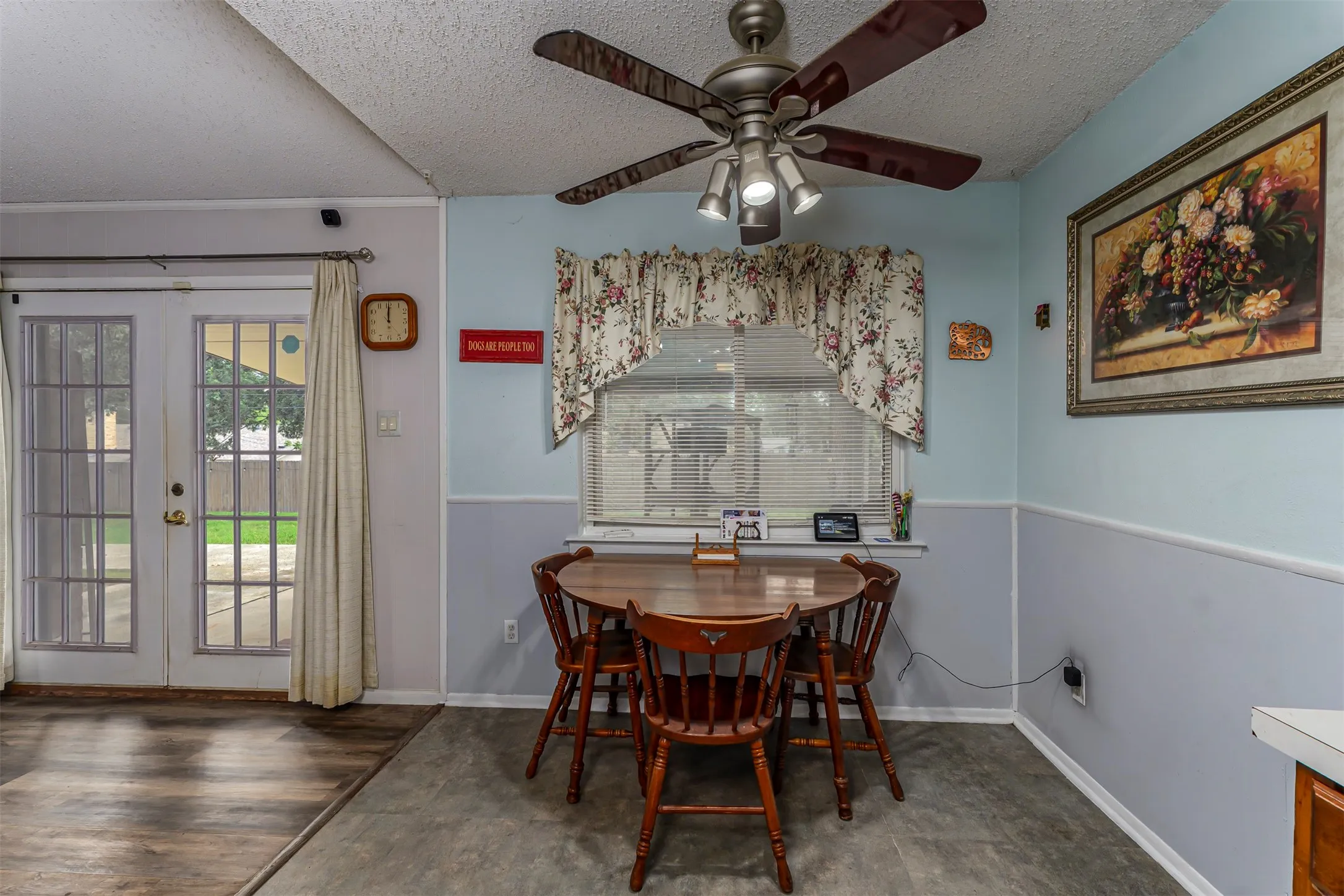 Multi-light ceiling fan, glass-paneled double doors, window with built-in blinds, and two-tone wall finish