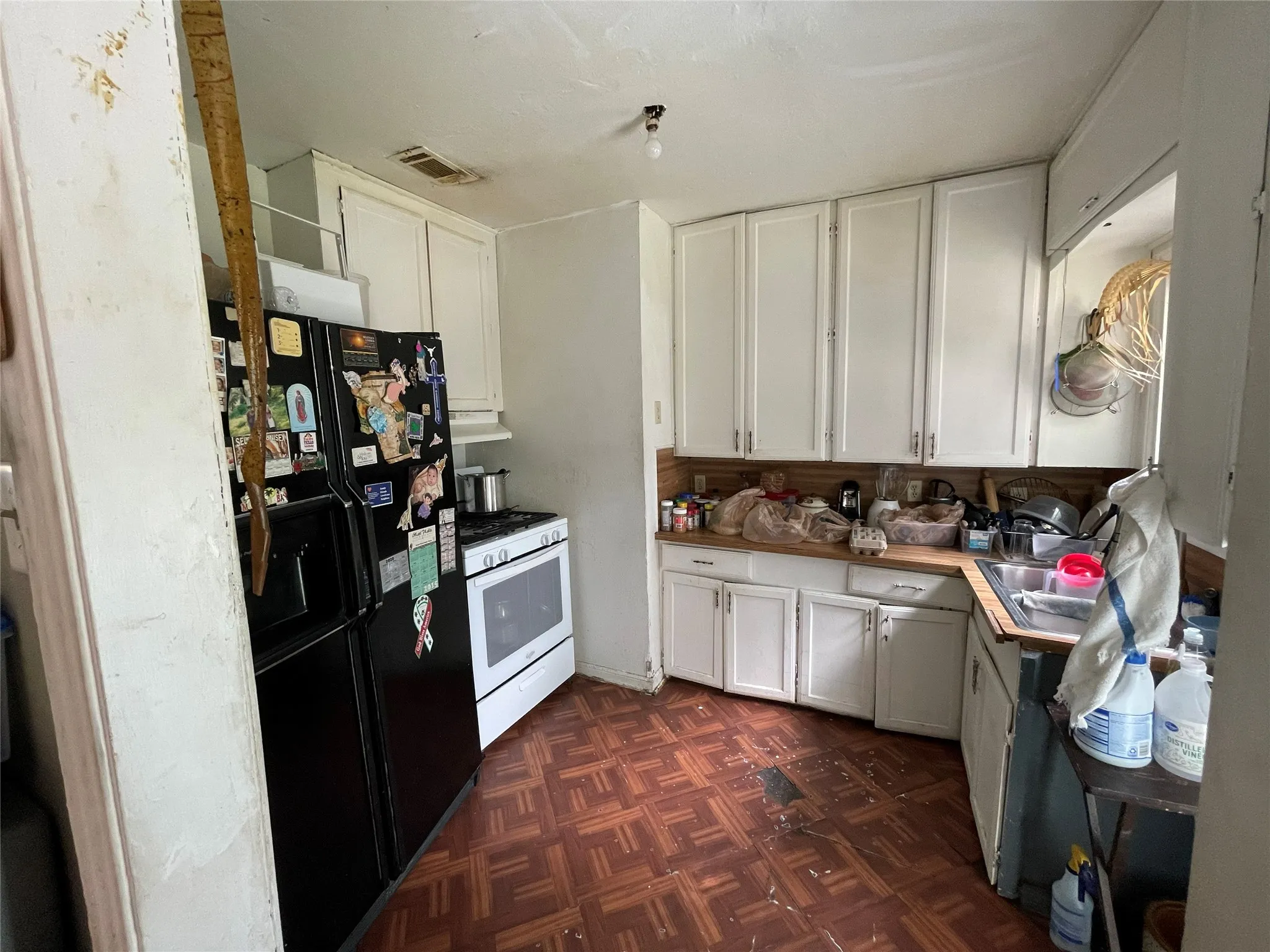Kitchen featuring white cabinetry, wooden countertops, tile flooring, and an integrated stove