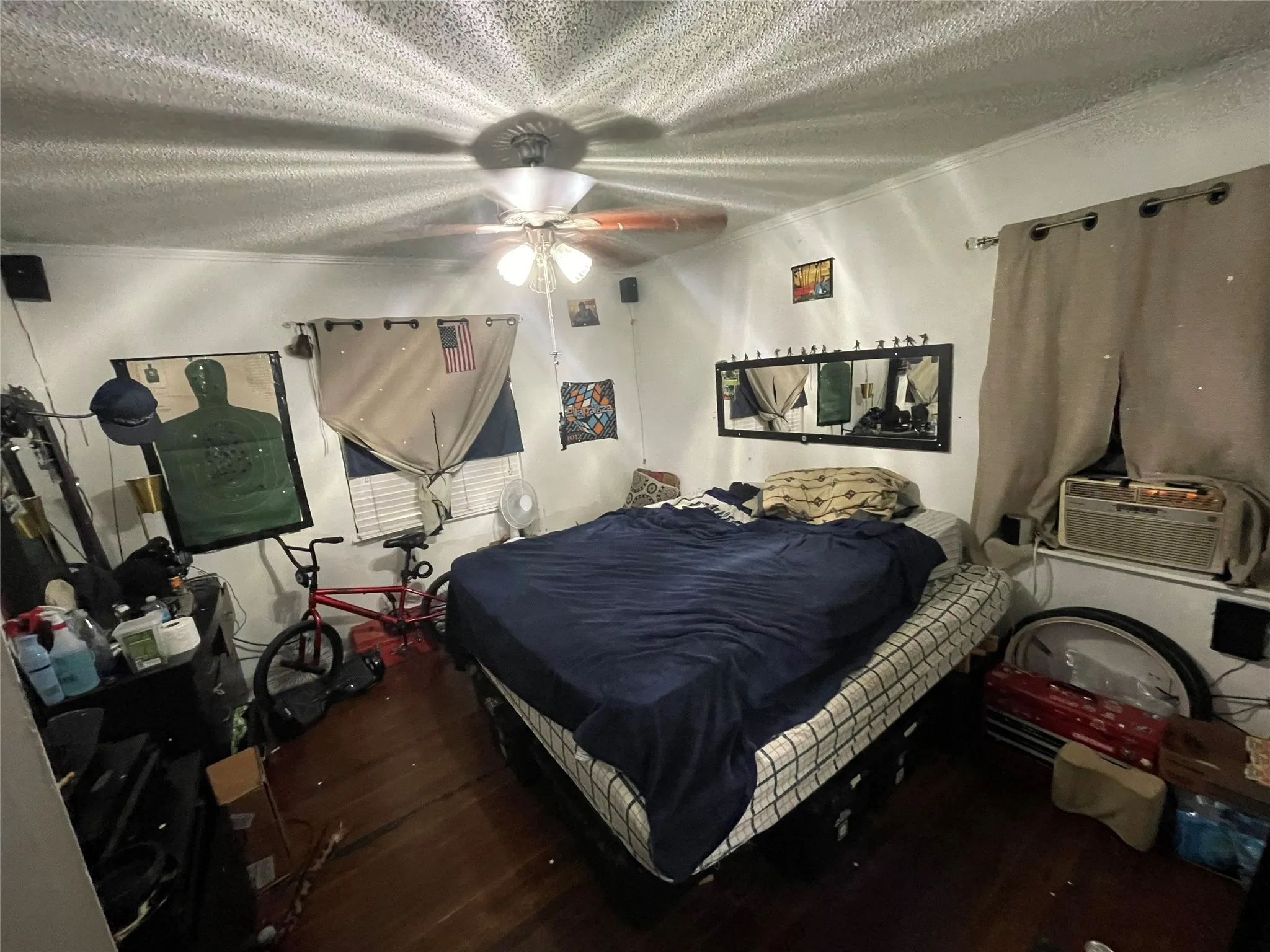 Hardwood flooring, ceiling fan with integrated light fixture, and wall-mounted mirror