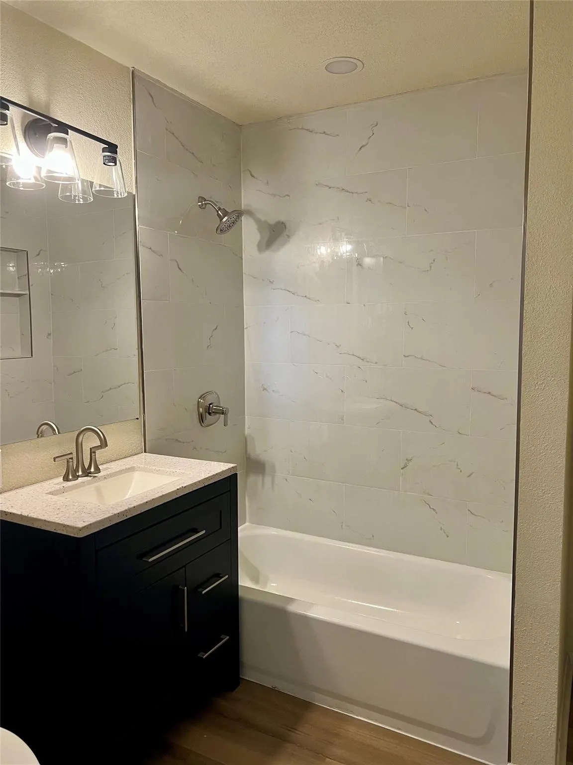 Dark finish vanity featuring a quartz countertop, rectangular drop-in sink, and metallic faucet