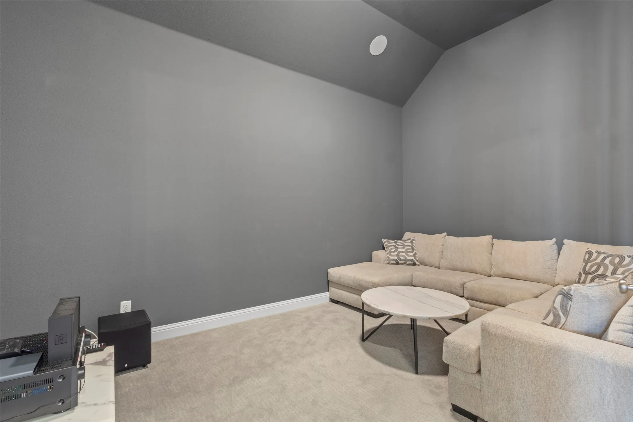 Vaulted ceilings, neutral wall tones, and plush wall-to-wall carpeting