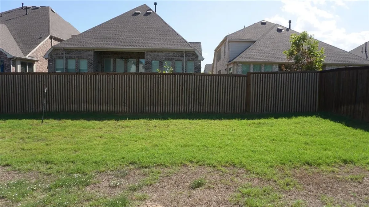 Private backyard featuring a fenced perimeter and an open lawn area