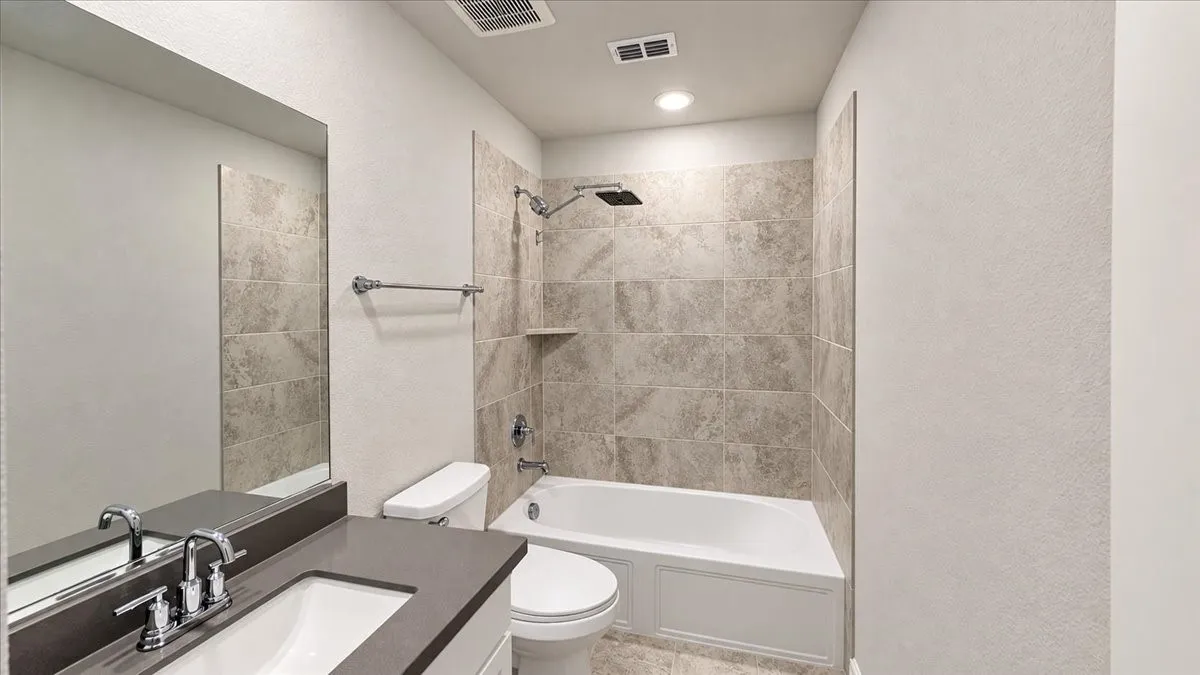 Bathroom featuring a vanity with a solid-surface countertop, rectangular undermount sink, and chrome fixtures