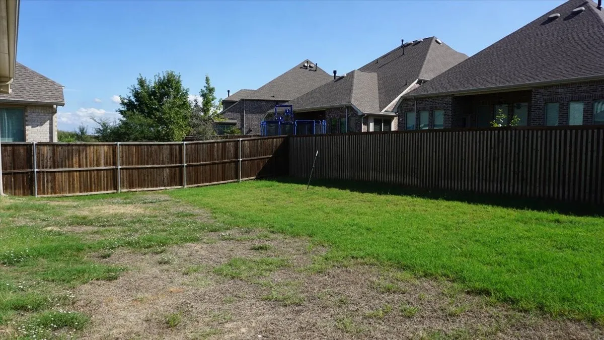 Private backyard featuring a full-perimeter wood fence and grass lawn