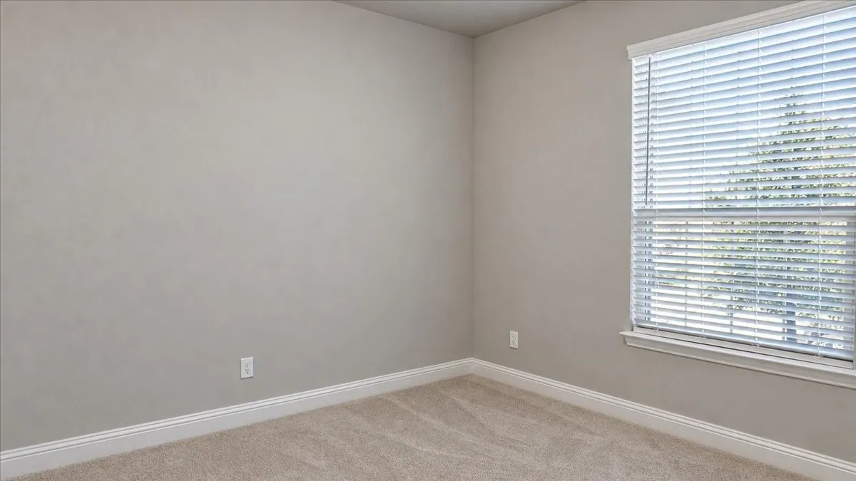 Neutral-toned interior walls, neutral-toned wall-to-wall carpeting, and horizontal slat window blinds