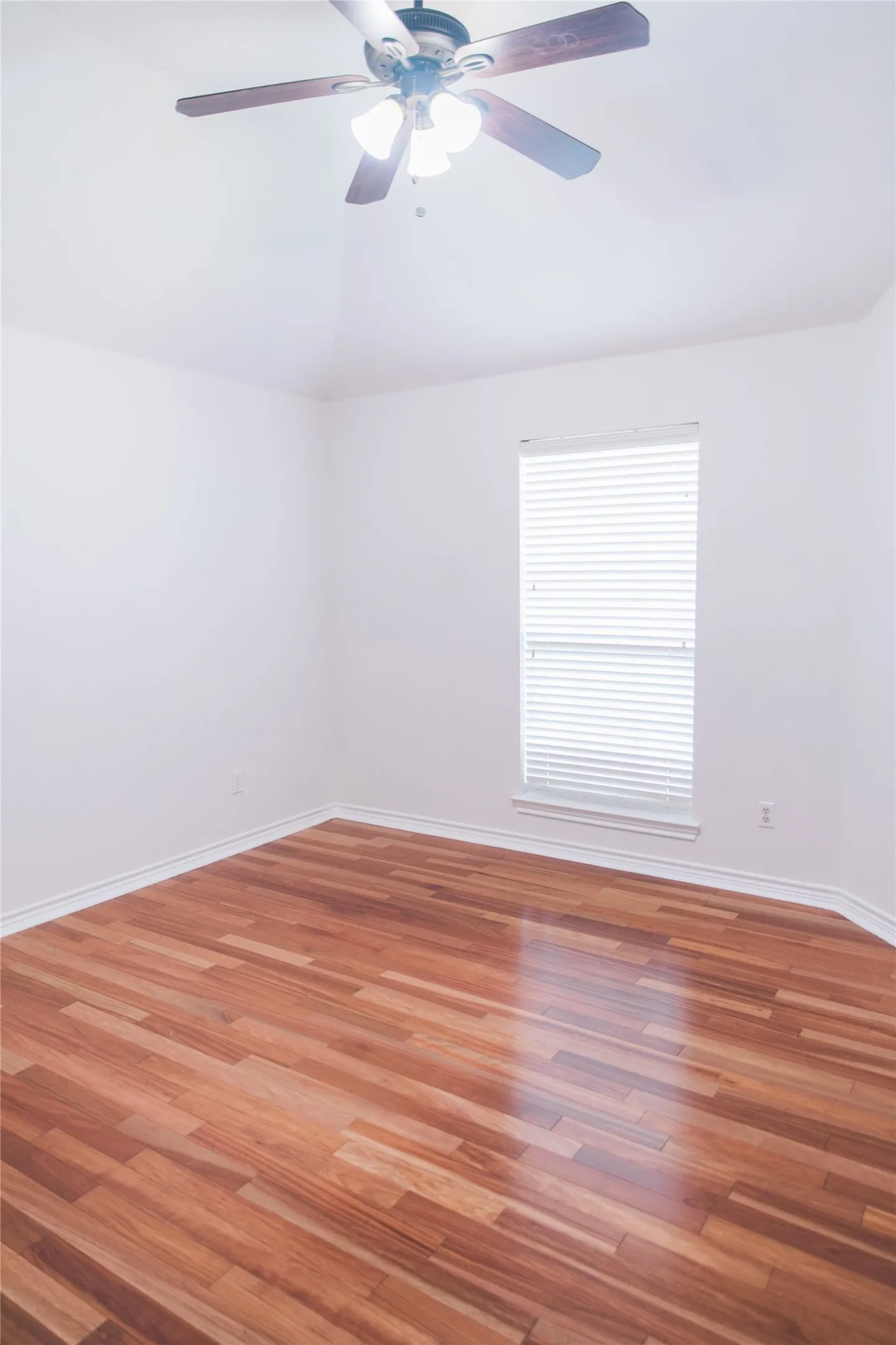 Vaulted ceilings, wood-finish flooring, and a ceiling fan with integrated lighting