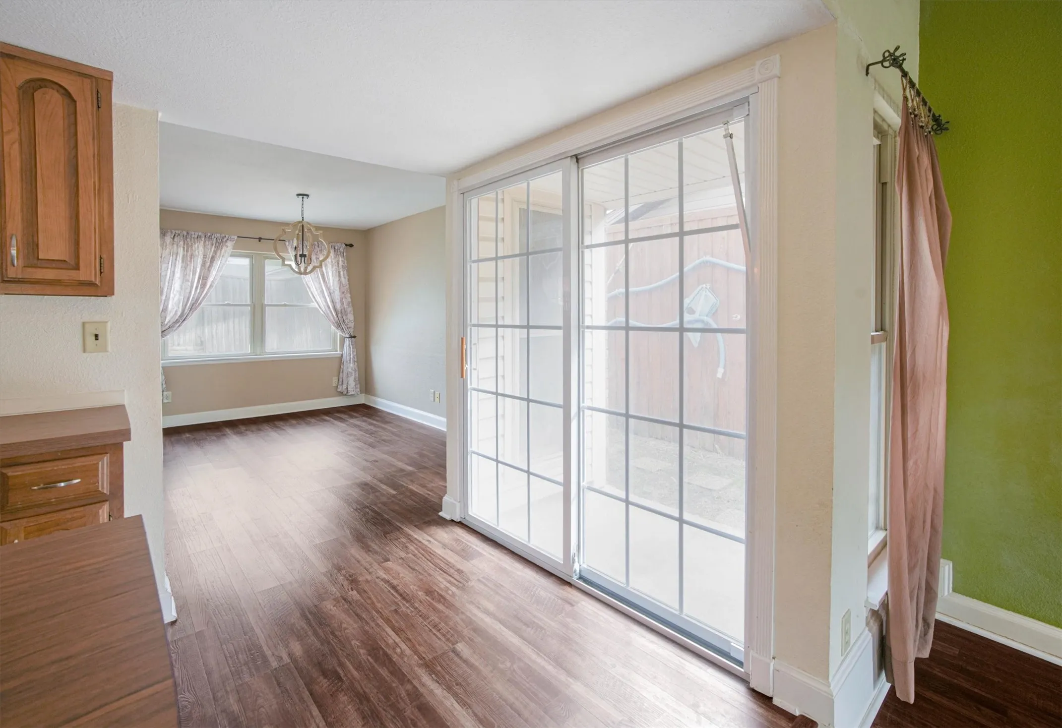 Sliding double paned glass door, luxury vinyl plank flooring, decorative chandelier.