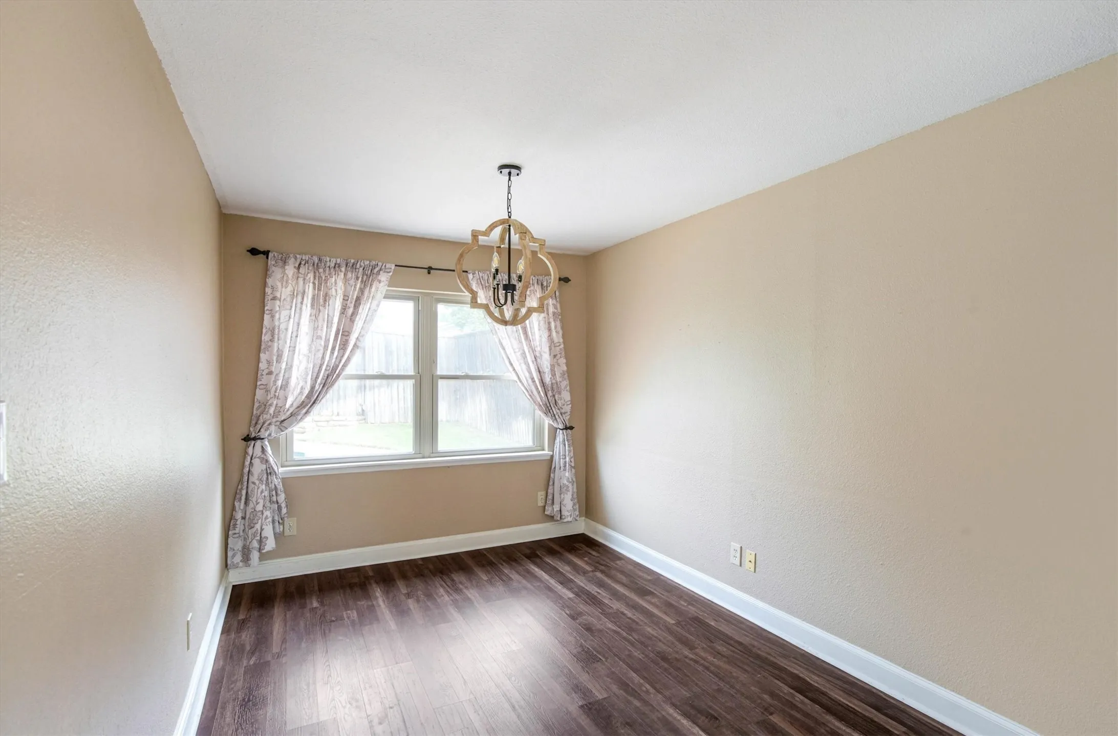 Room featuring luxury vinyl plank flooring, a multi-pane window, and a decorative chandelier light fixture
