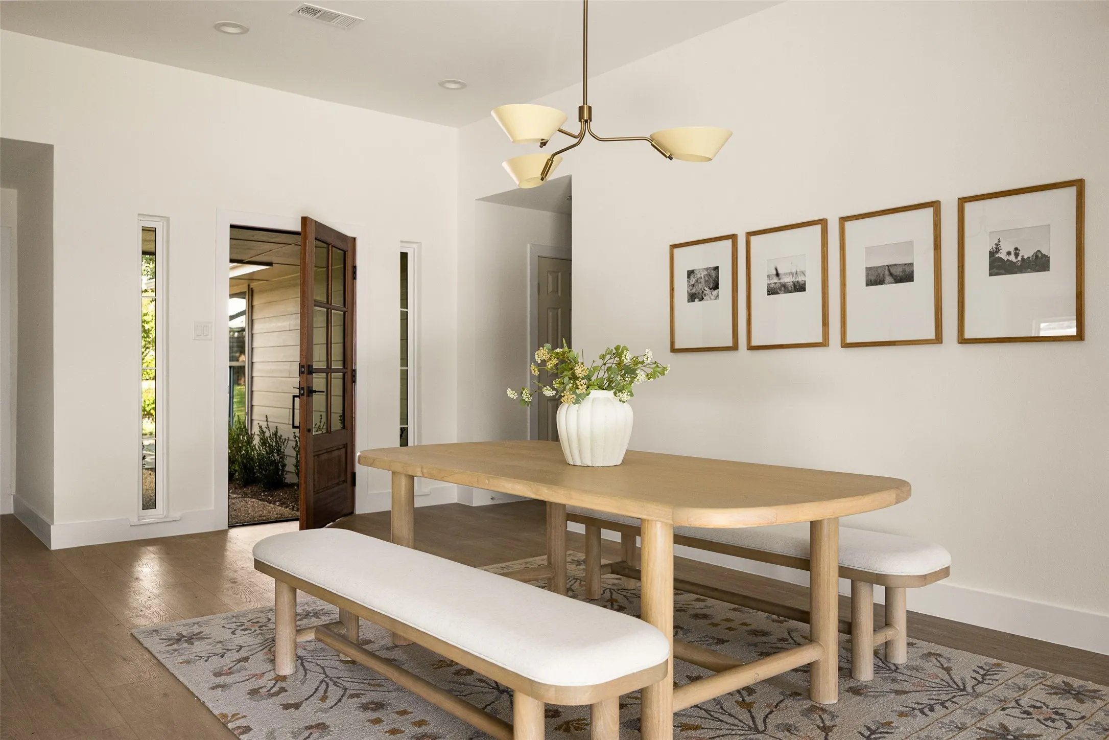 An elegant dining area welcomes you upon entry, featuring rich wood-like flooring, abundant natural light, and a warm, inviting atmosphere that sets the tone for the home.