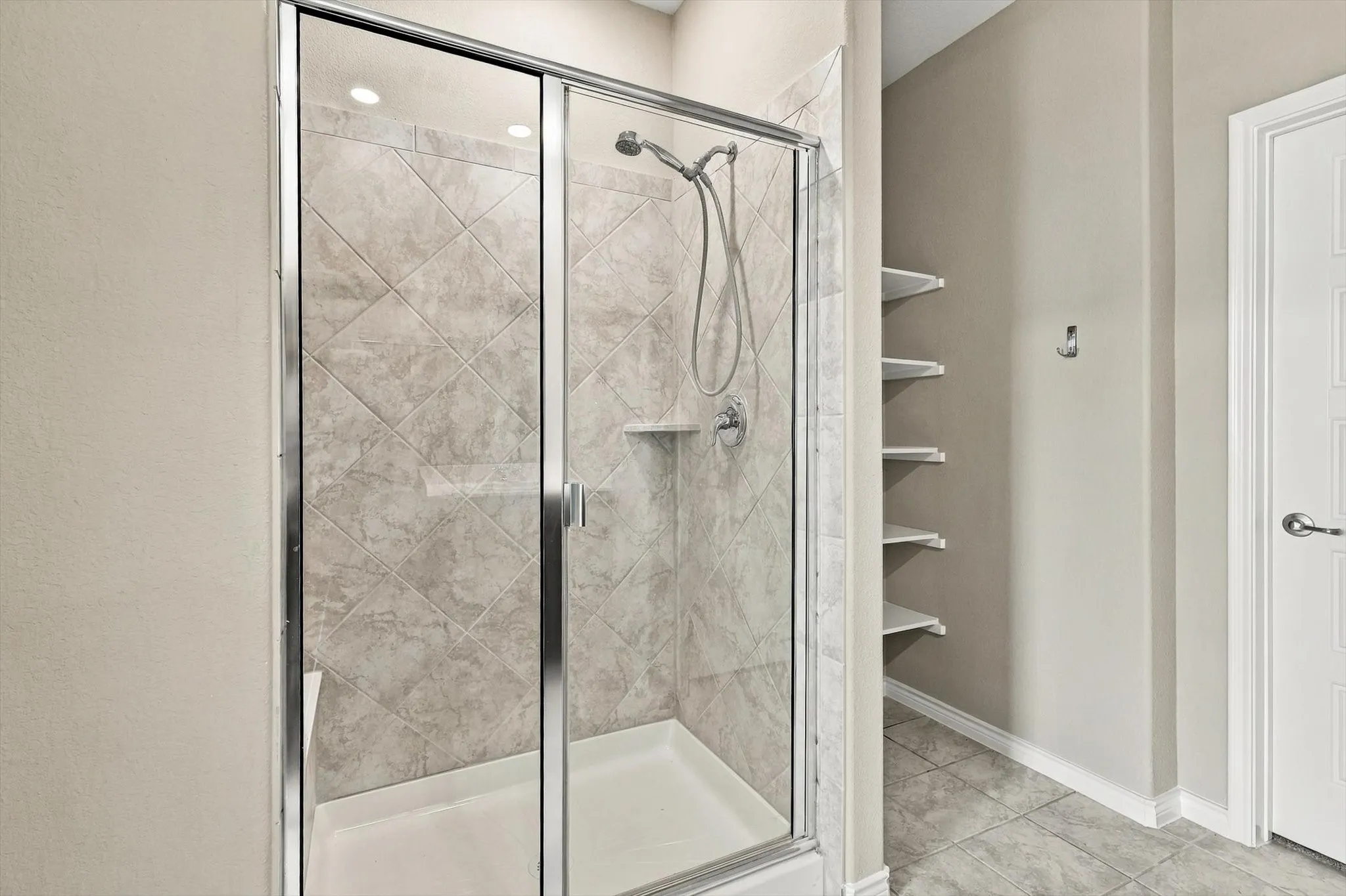 Primary bath shower and.  The open shelving allows plenty of storage.