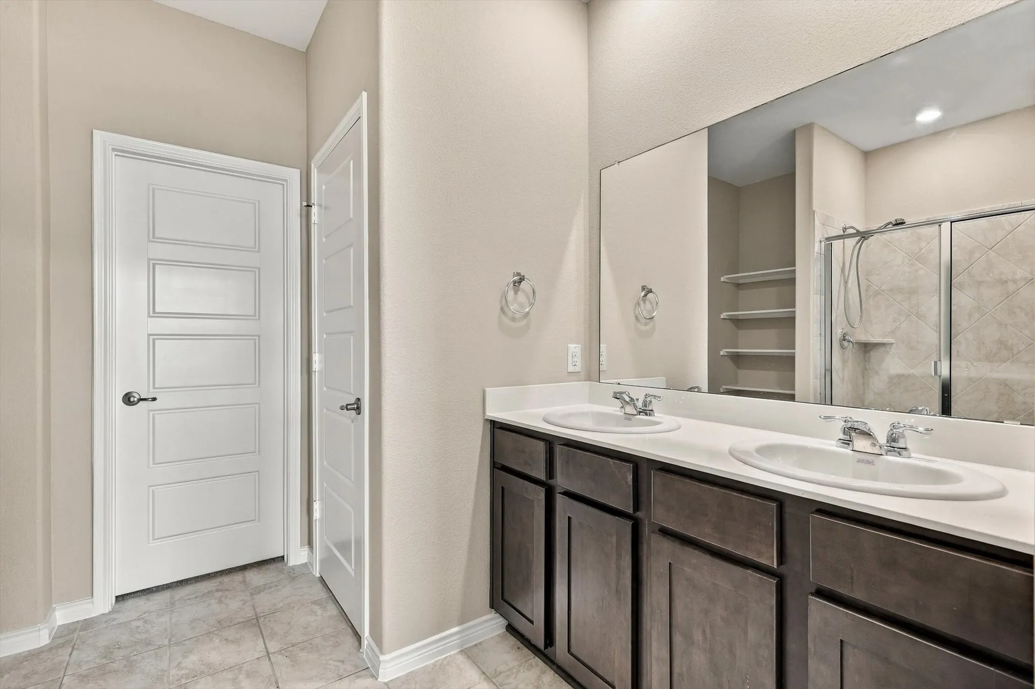 Primary Bath with dual sinks and freestanding shower.  Doors lead to private toilet area and walk in closet.