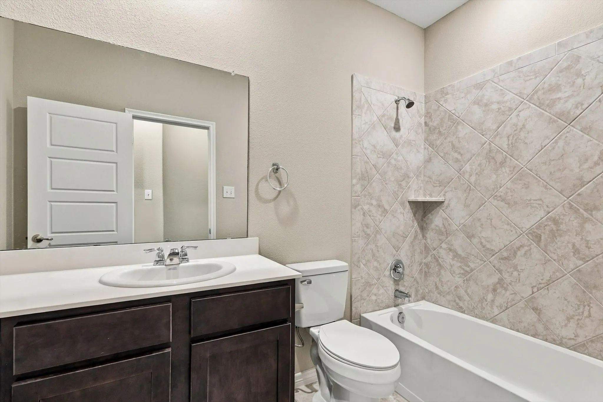 Secondary bath located off the hallway between bedroom 2 and 3.