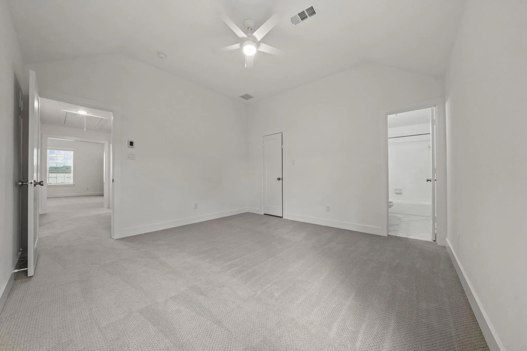 Vaulted ceiling with integrated multi-blade ceiling fan and wall-to-wall carpeting