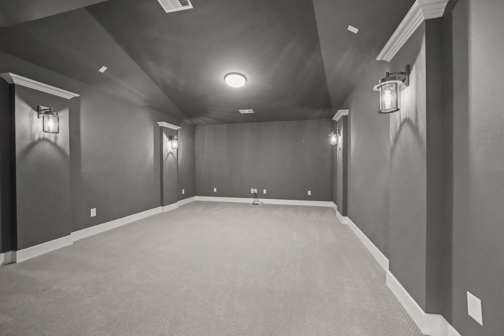 Vaulted ceilings featuring recessed lighting, wall-mounted lantern-style sconces, and crown molding