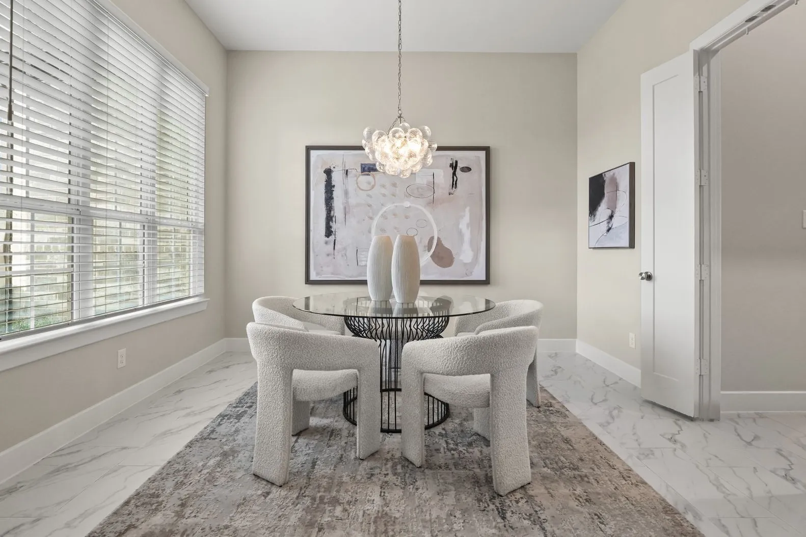 Light-filled room featuring large windows, stone-finish tile flooring, and a decorative multi-bulb pendant chandelier