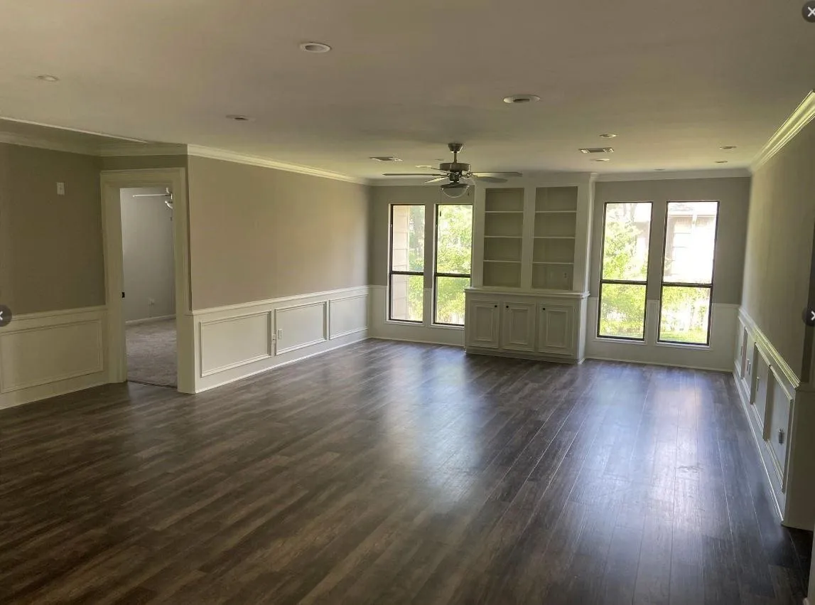 Wood-finish flooring, custom built-in cabinetry, wainscoting, recessed lighting, and a ceiling fan